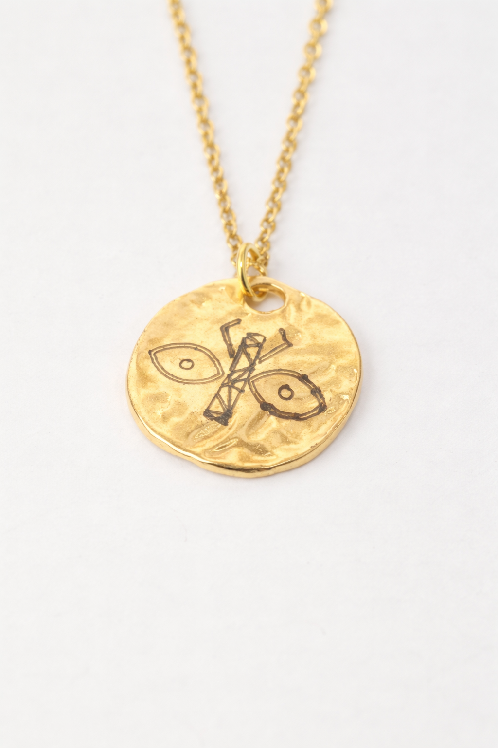 Stainless steel necklace with an elegant round pendant engraved with a scarab symbol, the brand’s emblem, combining sophisticated design with durable, radiant material.