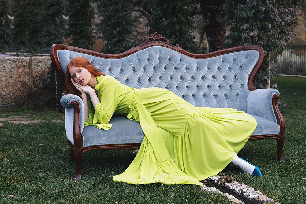 Lime green maxi dress with feather-trimmed shoulders worn by a model.