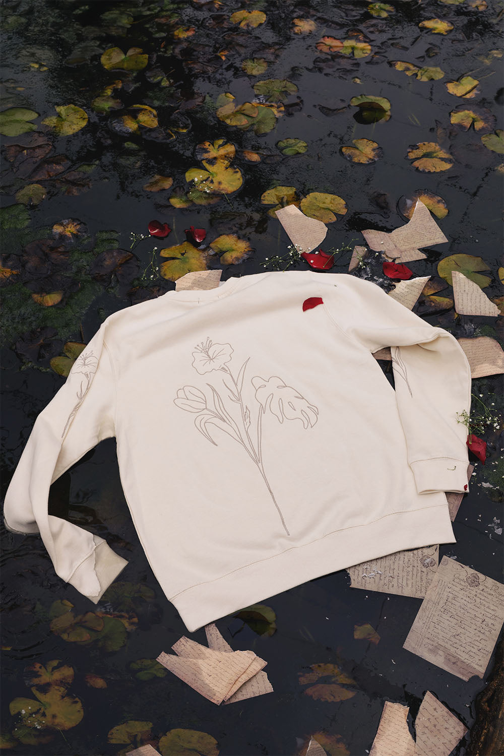 Beige oversized sweatshirt with embroidered floral details, back view.