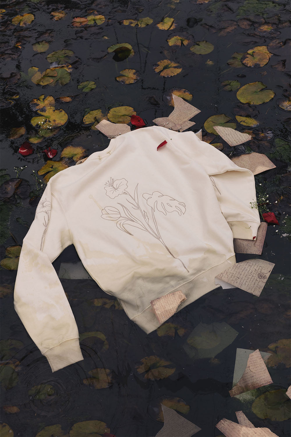 Beige oversized sweatshirt with embroidered floral details, back view.