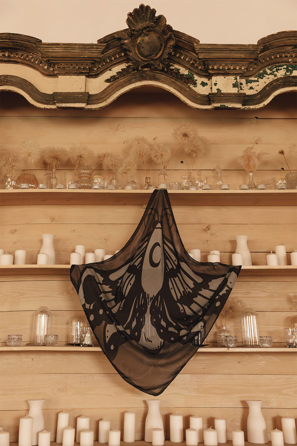 Square modal and cashmere scarf in black, gray and taupe tones, featuring a large stylized moth with anatomical wing details and a dark border.
