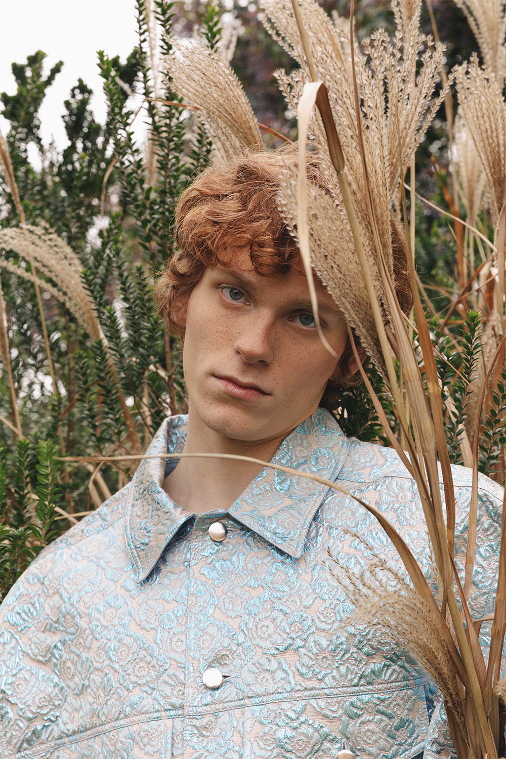 Oversized blue and silver brocade jacket worn by a model.