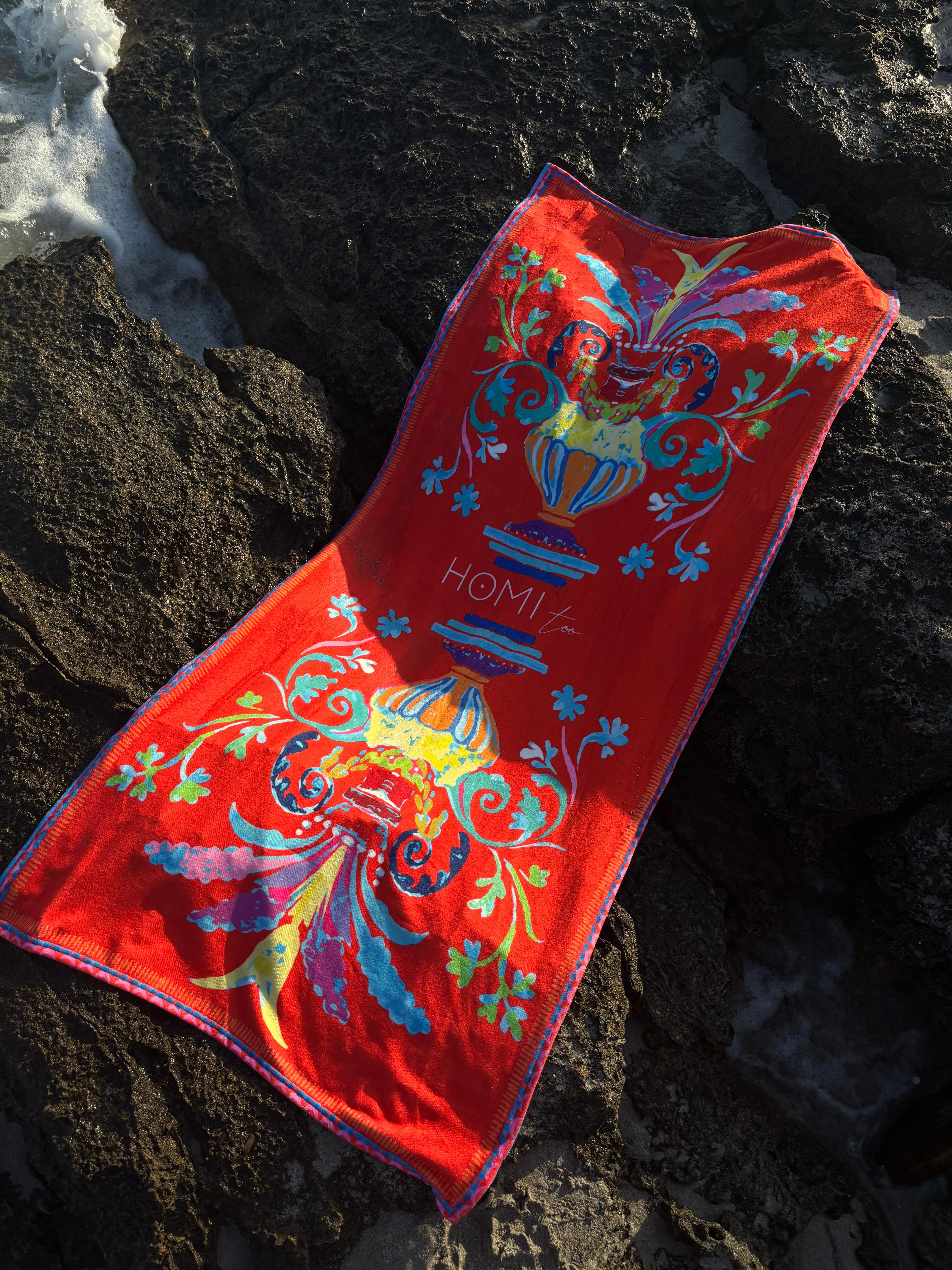 Elegant beach towel in soft terry cloth 75x150 cm, with exclusive print inspired by vibrant Sicilian patterns, red-orange tones evoking the warmth and passion of the Mediterranean.