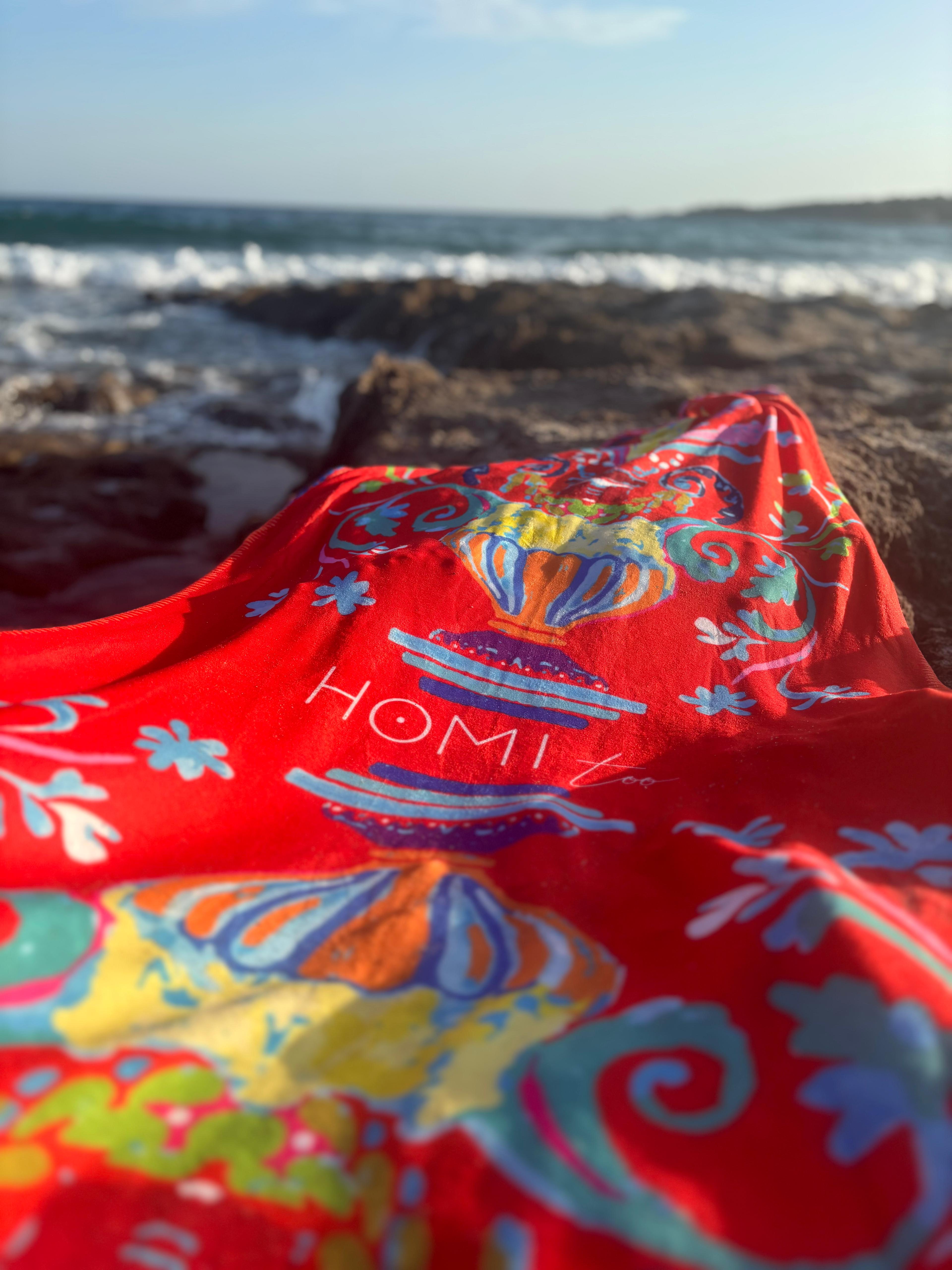 Elegant beach towel in soft terry cloth 75x150 cm, with exclusive print inspired by vibrant Sicilian patterns, red-orange tones evoking the warmth and passion of the Mediterranean.