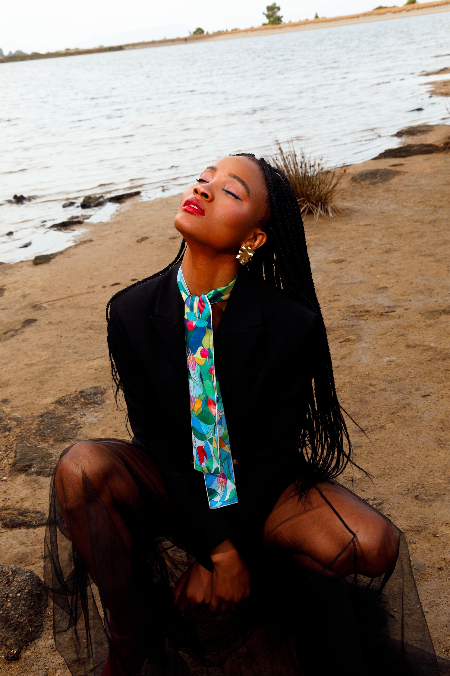 Silk scarf-tie worn around the neck by a model, showcasing the delicate stylized floral print and versatile styling.