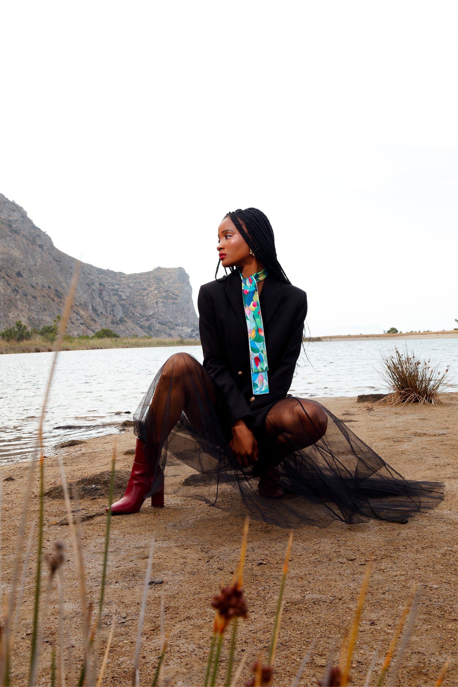 Silk scarf-tie worn around the neck by a model, showcasing the delicate stylized floral print and versatile styling.