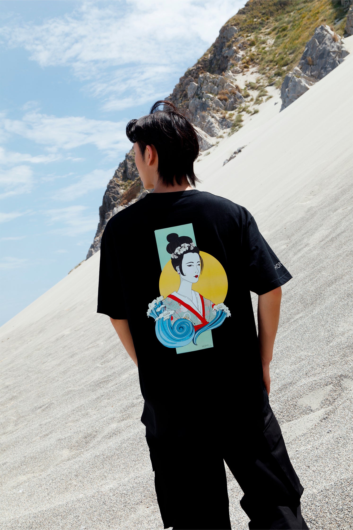 Back view of black short-sleeved oversized unisex t-shirt worn by a model, featuring hand-painted Geisha graphic printed with vibrant colors and artistic details.