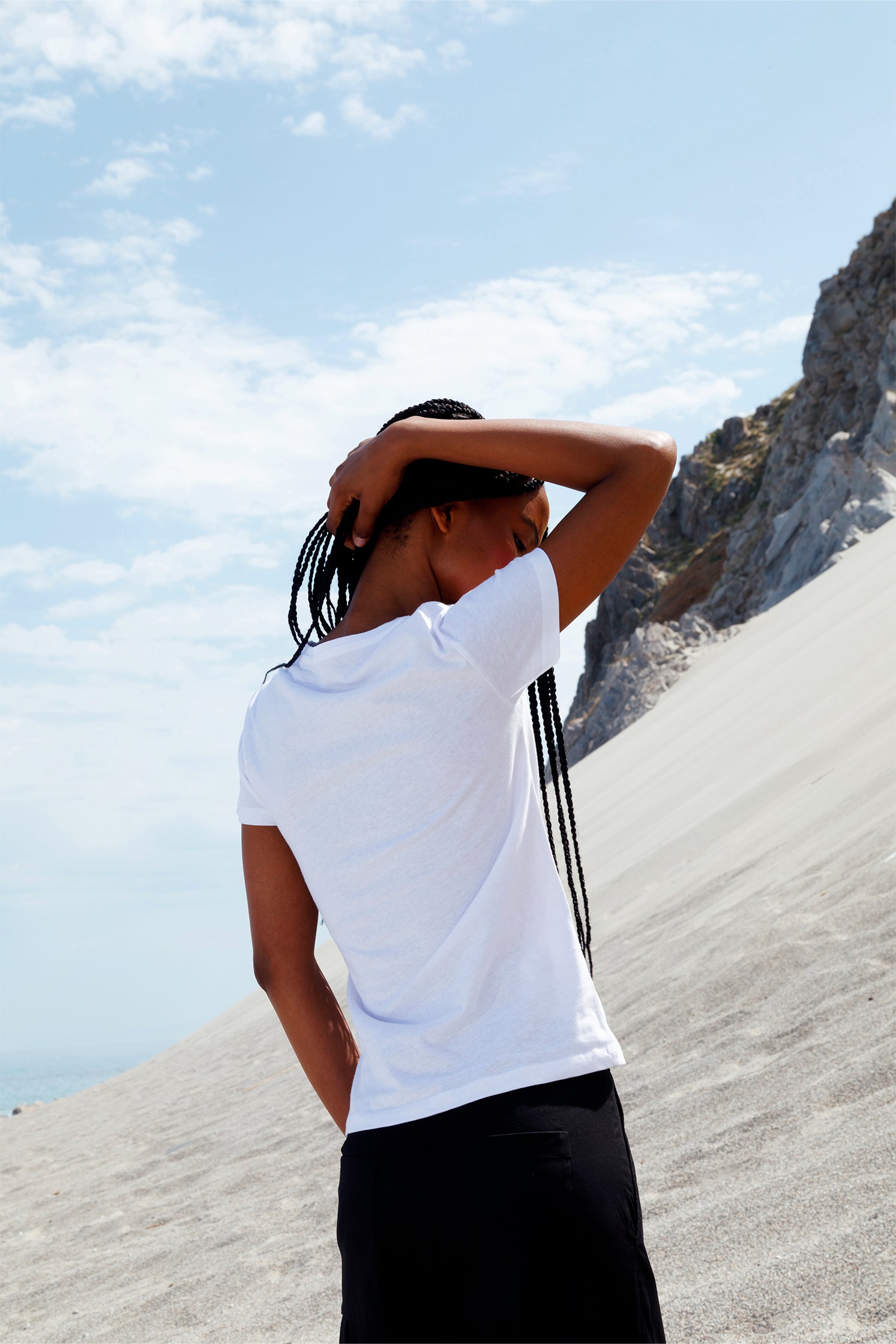 Back view of the white slim women's t-shirt worn by a model.