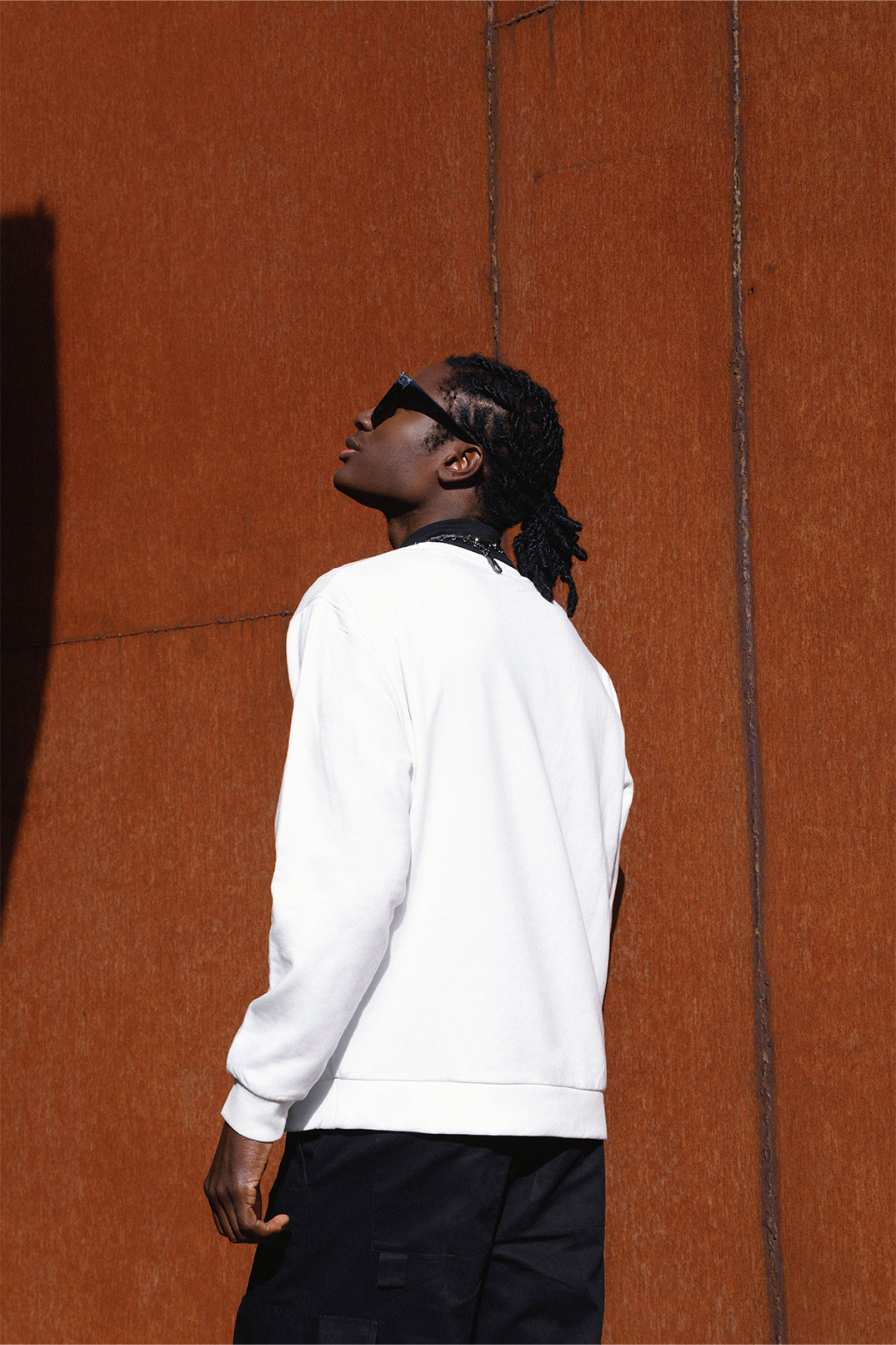 Back view of the white oversized sweatshirt worn by a model, featuring a relaxed fit and long sleeves.