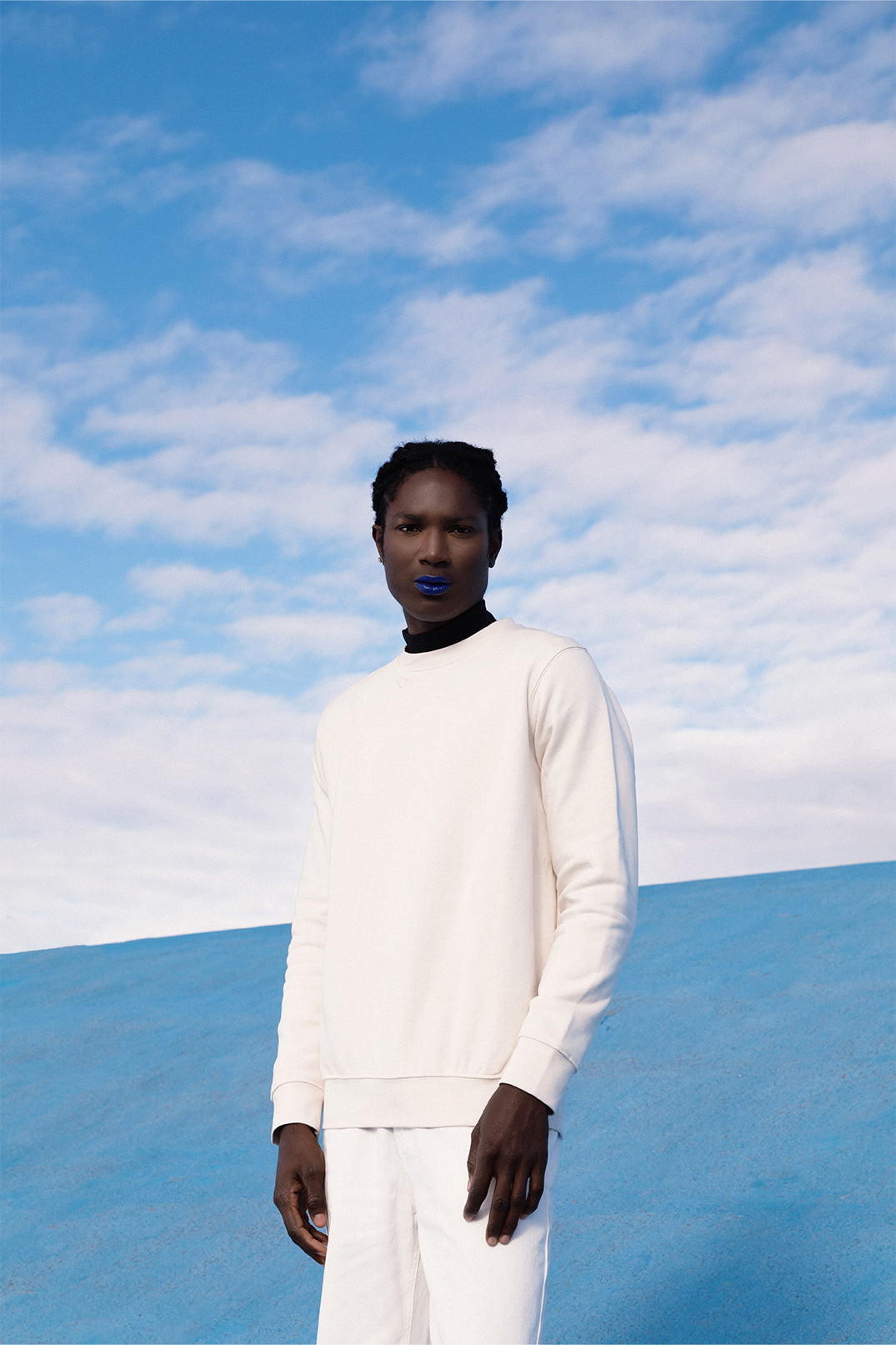 White oversized sweatshirt worn by a model, featuring a relaxed fit and long sleeves.