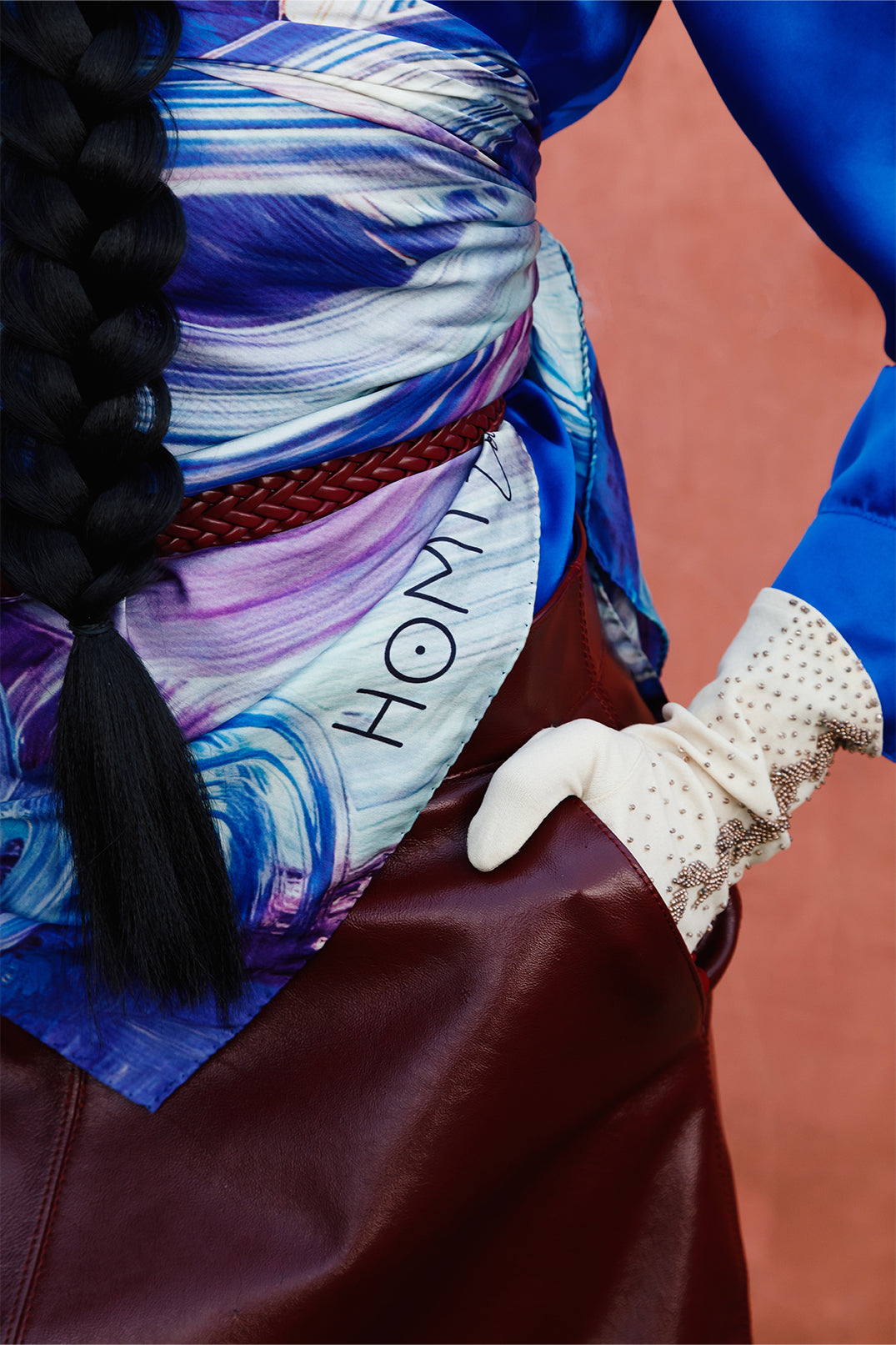 Close-up of the silk twill scarf 90x90 cm worn by a model as a top, highlighting the sea-inspired print with fluid brushstrokes in different shades of blue and the soft texture of the fabric.