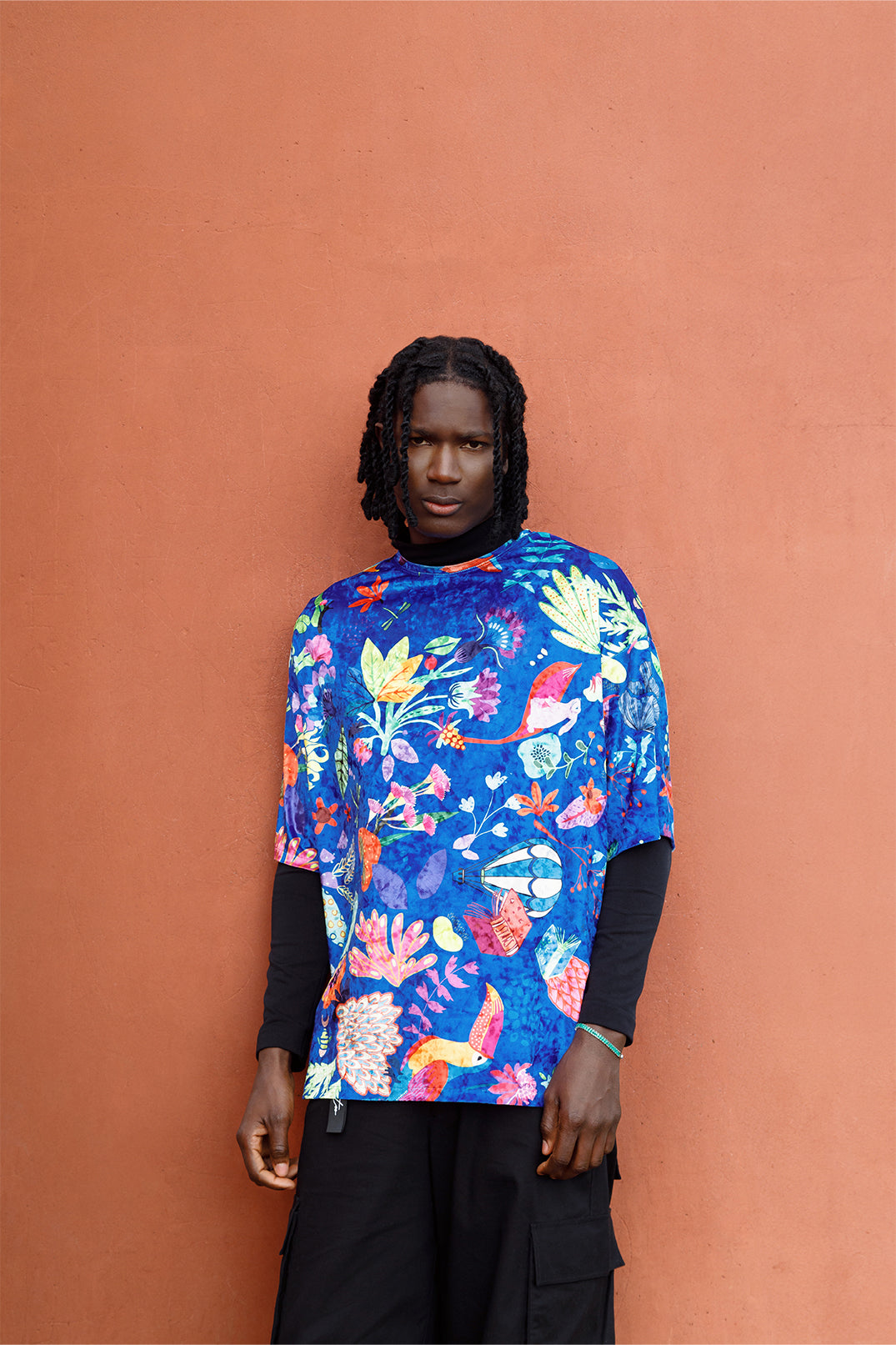 Blue velvet unisex oversized T-shirt worn by a model, featuring an exclusive artistic graphic and short sleeves.