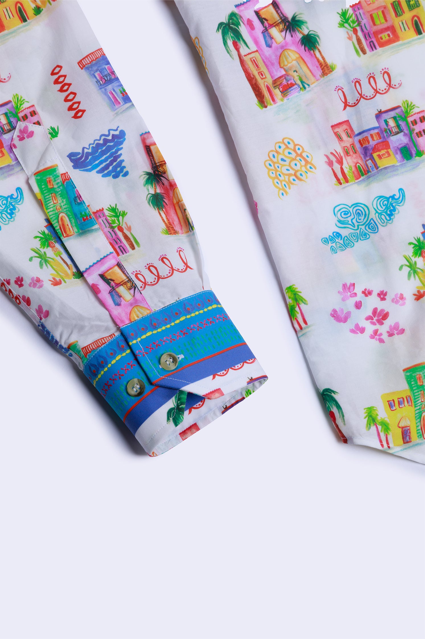 Close-up of the pattern of colorful houses on the cotton shirt and the cuff, showing intricate design details and vibrant colors.