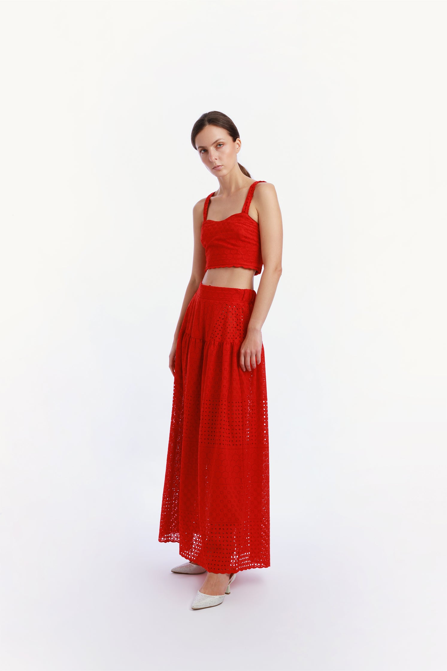 Side view of the red sangallo set worn by a model, featuring a long skirt with elastic waistband and a top with elasticated back, offering elegant and comfortable fit.