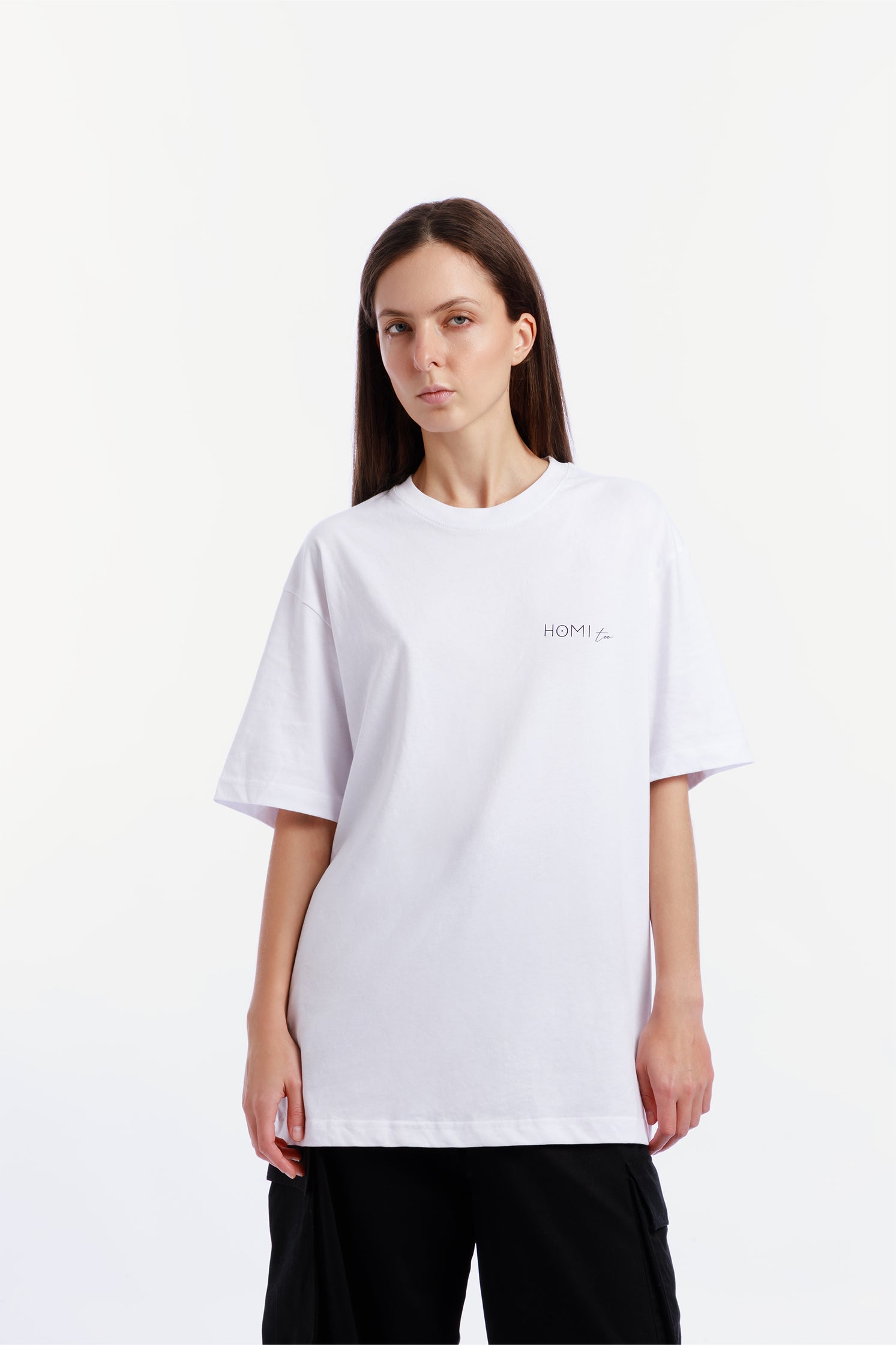 Front view of the oversized unisex white T-shirt made of high-quality cotton, worn by a model, featuring a modern cut, "Homi Too" logo on the left chest.