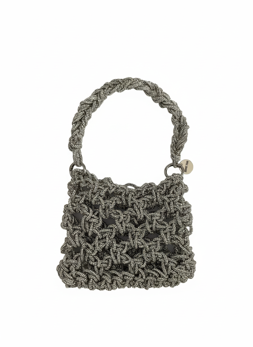 Silver handmade bag crafted with sparkling luminous thread, soft three-dimensional shape, braided handle and metal ring details.