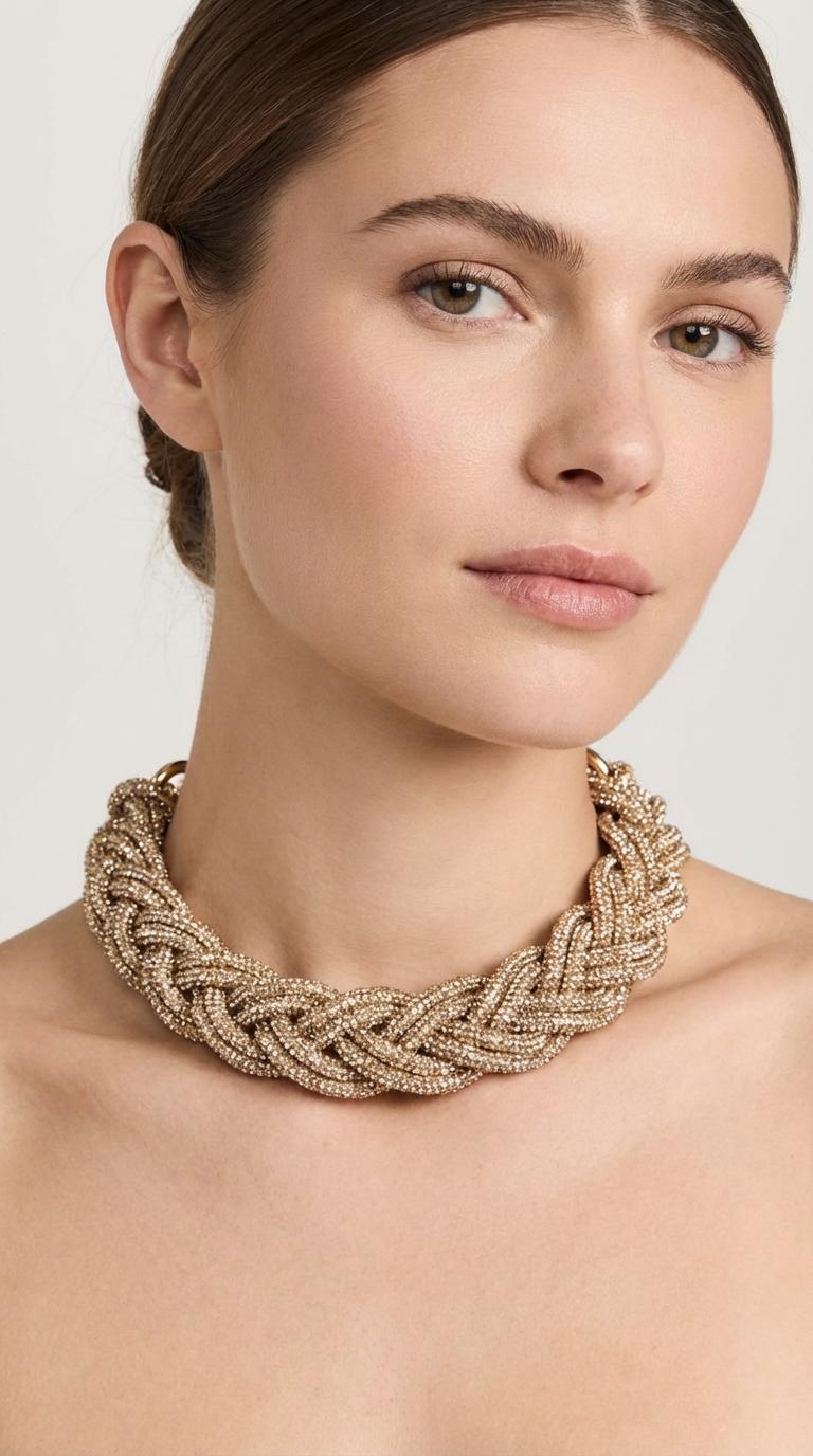 Gold handmade braided necklace made with luminous sparkling thread, three-dimensional design with metal ring closure worn around the neck by a female model.