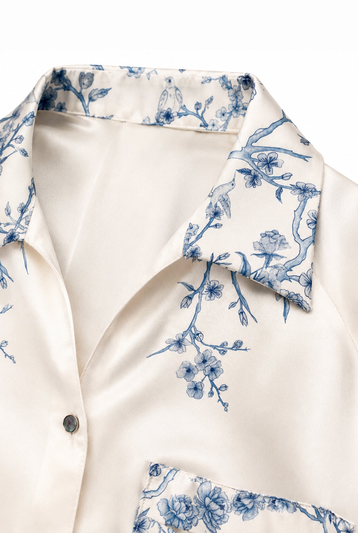 Close-up of the blue floral details on the ivory long shirt.