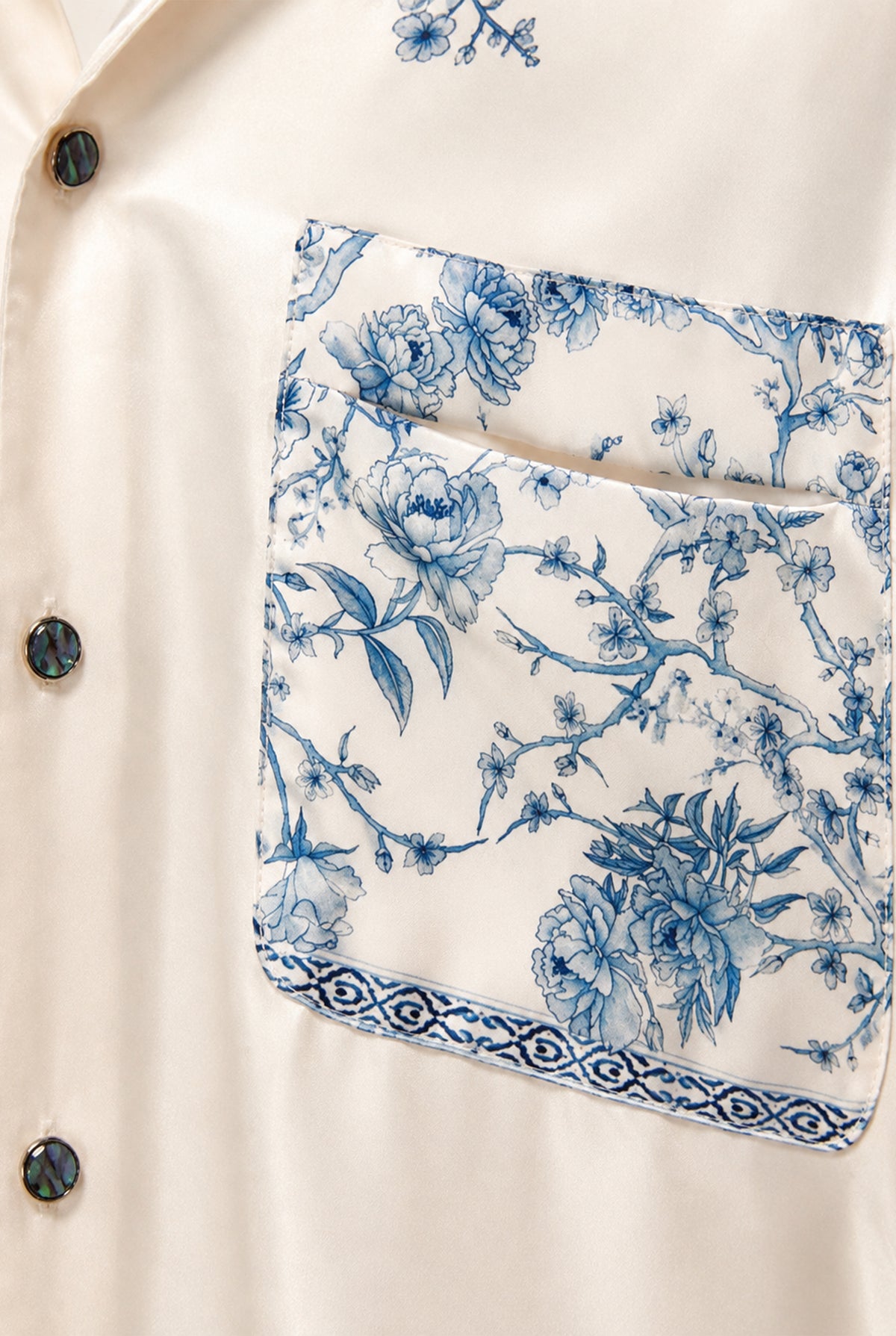 Close-up of the blue floral details on the ivory long shirt.