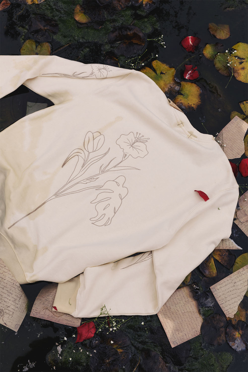 Beige oversized sweatshirt with embroidered floral details, back view.