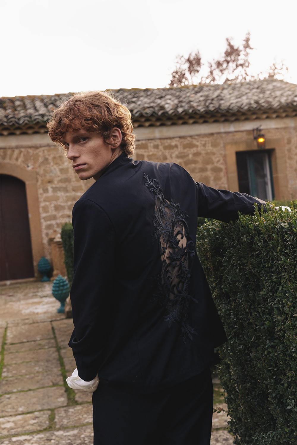 Black jacket with embroidered details worn by a model.