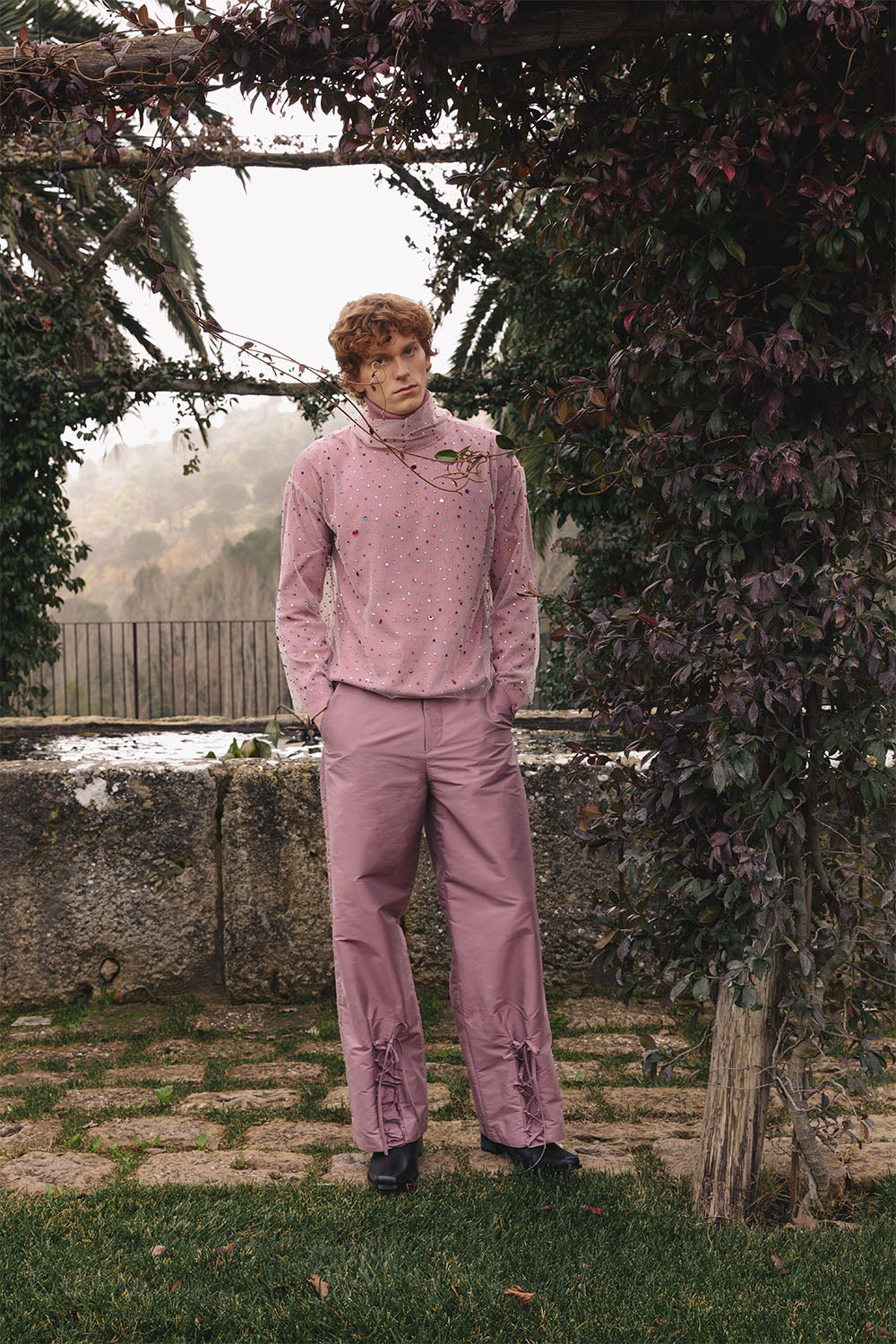 Pink taffeta wide-leg trousers with lace-up details worn by a model.