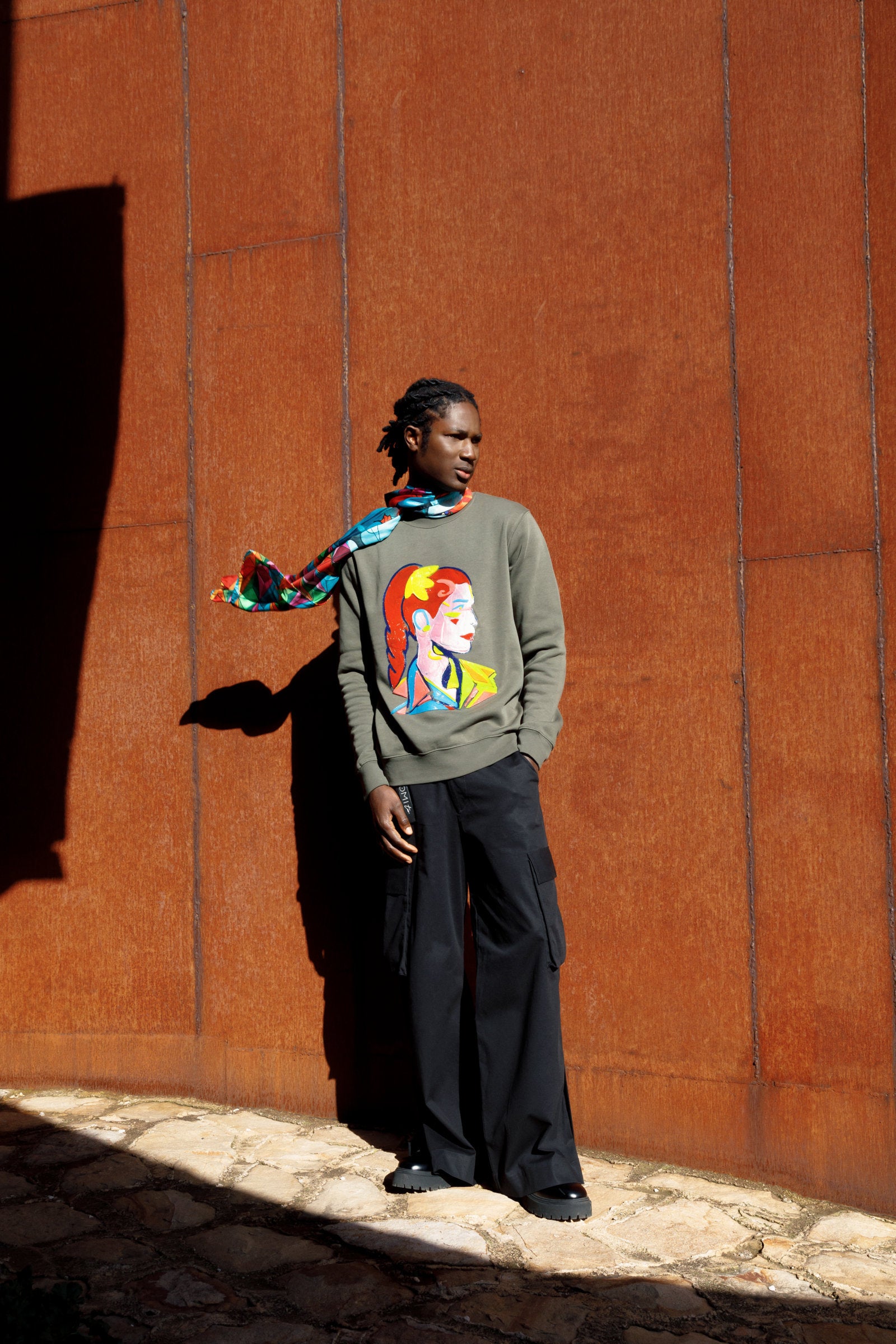 Elegant 70x180 cm scarf in 100% silk featuring a koi carp design, with flowing lines and intertwined colors creating a sense of movement and depth worn around the neck by a model.