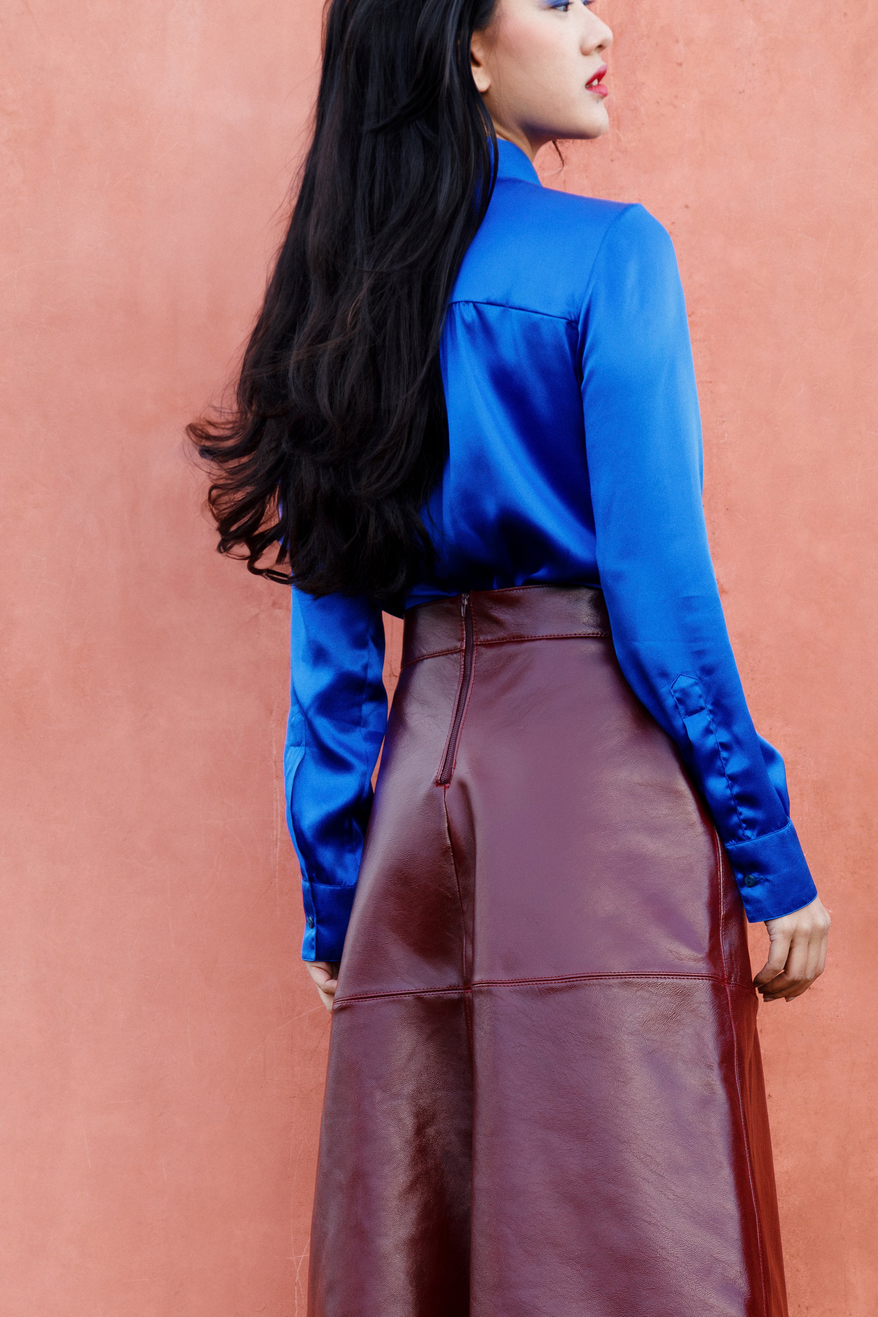 Back side of the deep blue silk shirt worn by a model, fluid and lightweight.
