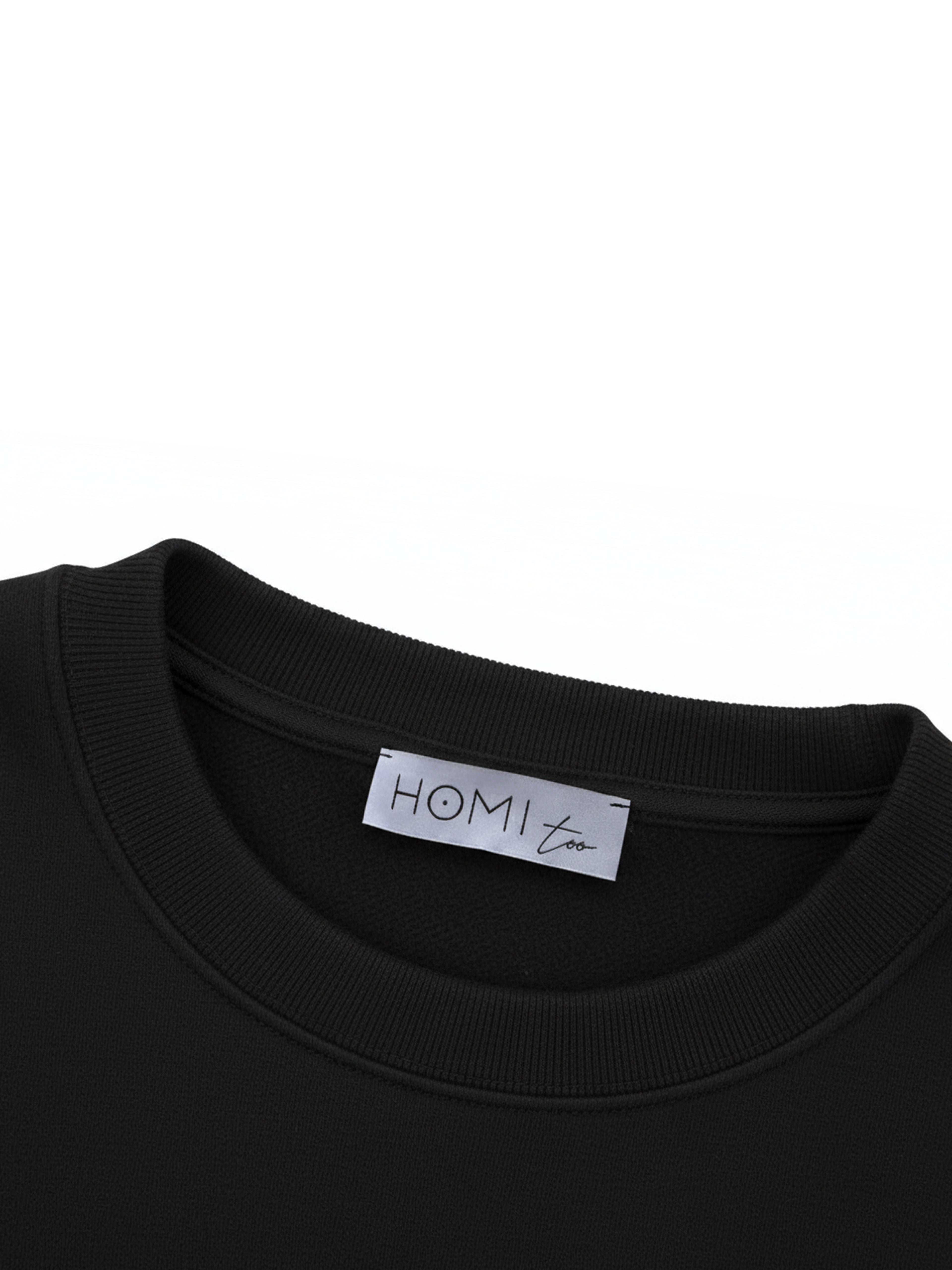 Close-up of the HOMI TOO logo label sewn on the back neckline of the sweatshirt.