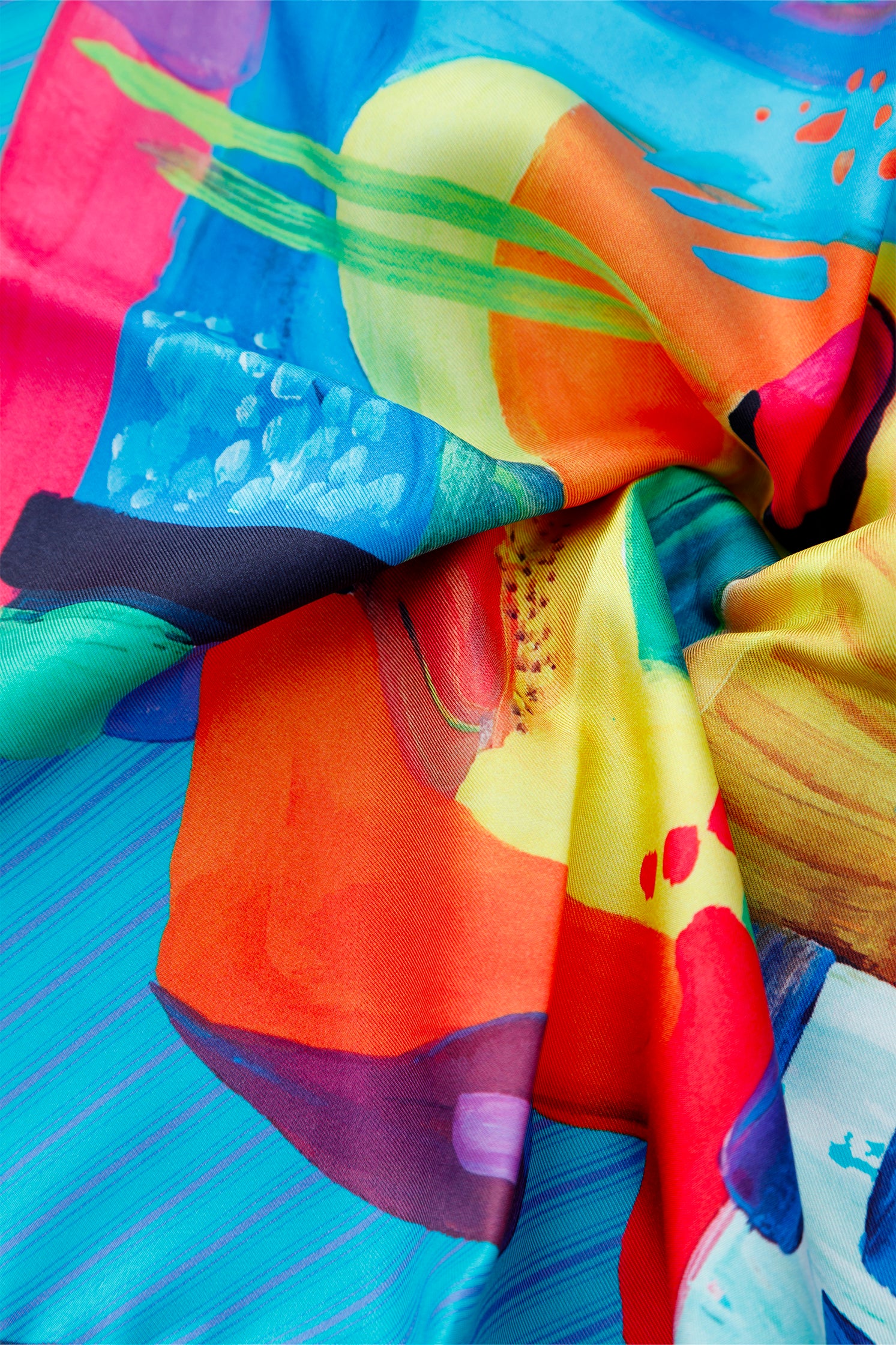 Close-up of the abstract multicolor geometric print on the silk scarf, showing vibrant colors, intricate design, and fine craftsmanship.