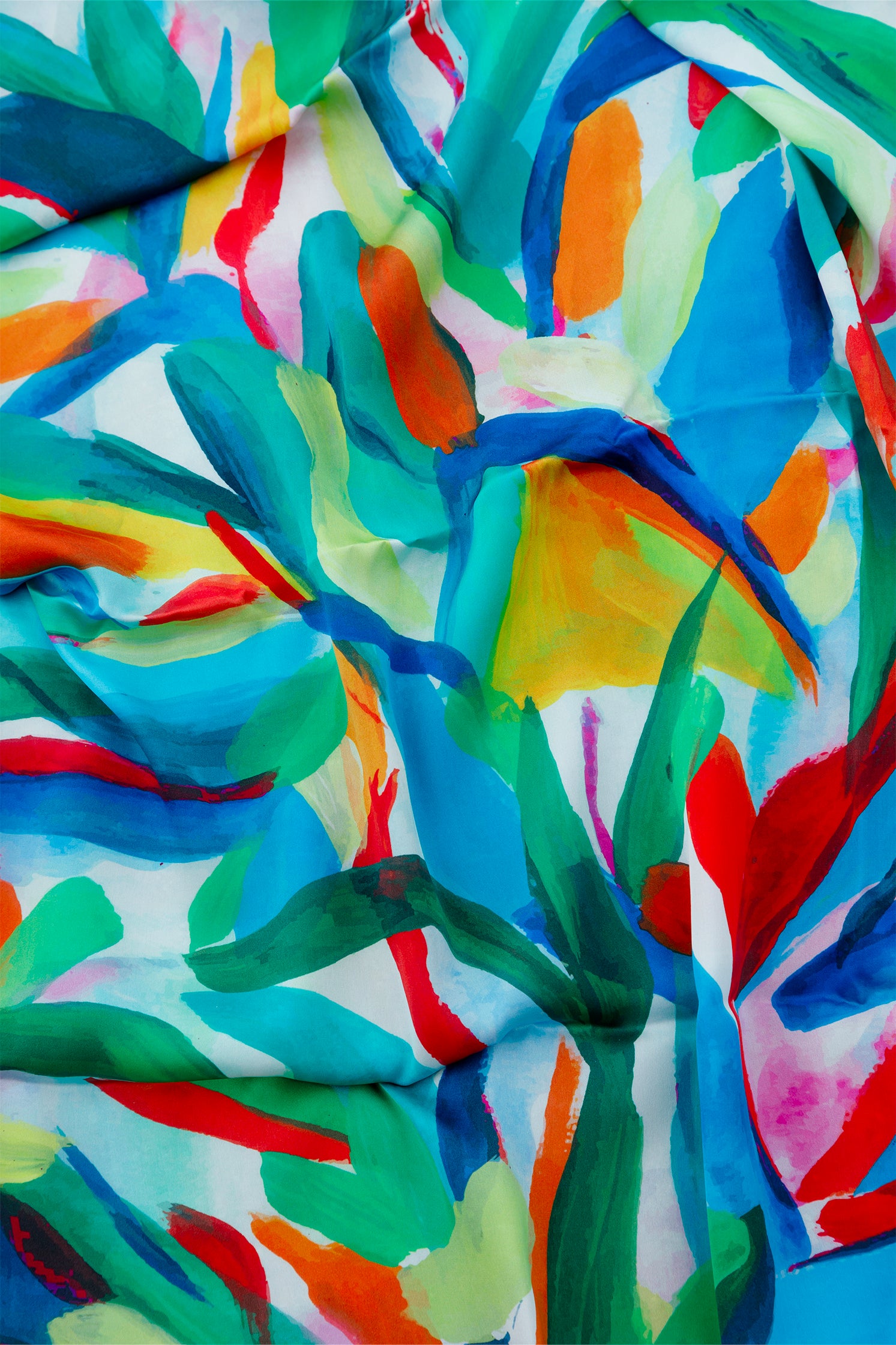 Close-up of the stylized leaf print on the pure silk scarf, showing vibrant colors, artistic details, and refined composition.