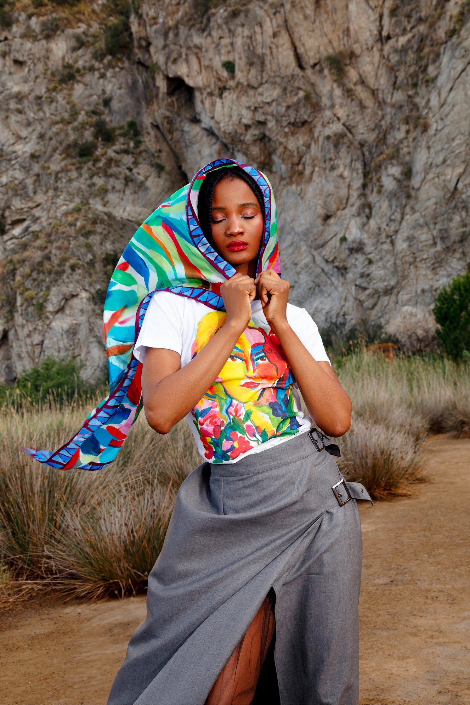 Silk scarf worn on the head by a model, showing the stylized colorful leaf print and contemporary artistic design.