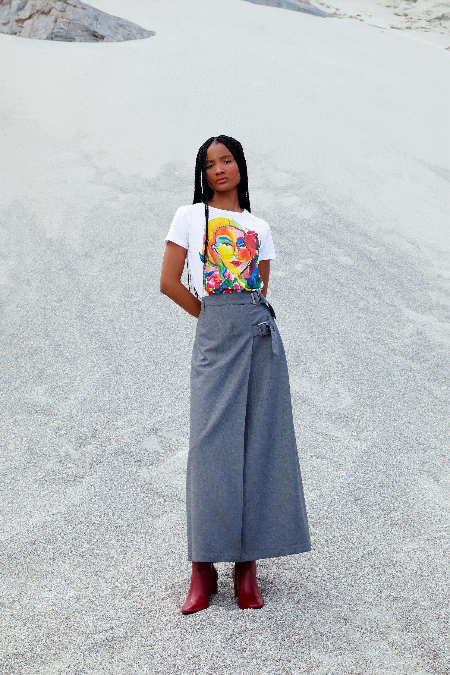 Long gray wrap skirt in cool 100% wool worn by a model, featuring elegant wrap design, lightweight breathable fabric and adjustable metal buckle closure.