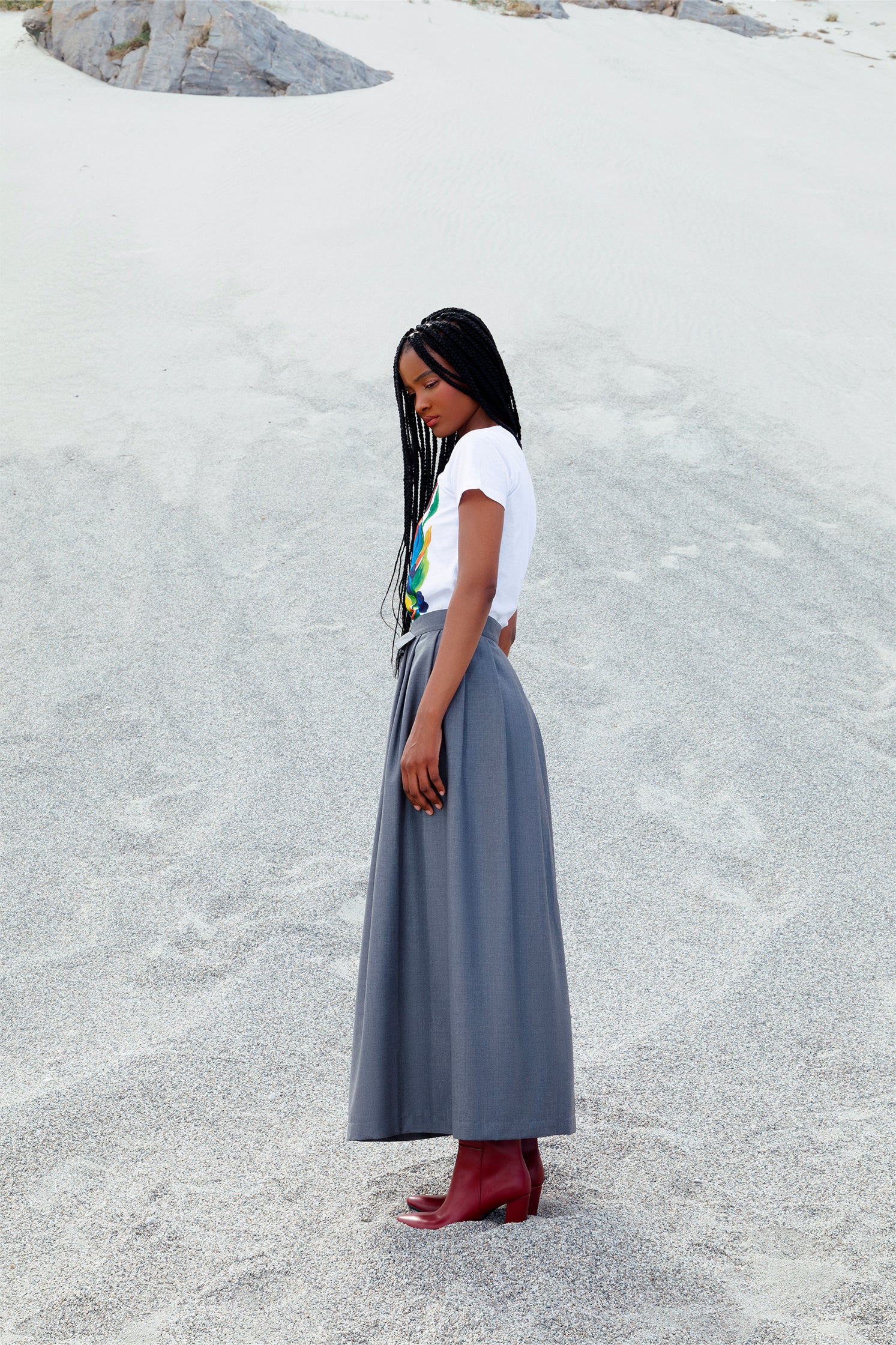Side view of the long gray wrap skirt worn by a model, featuring elegant wrap design.