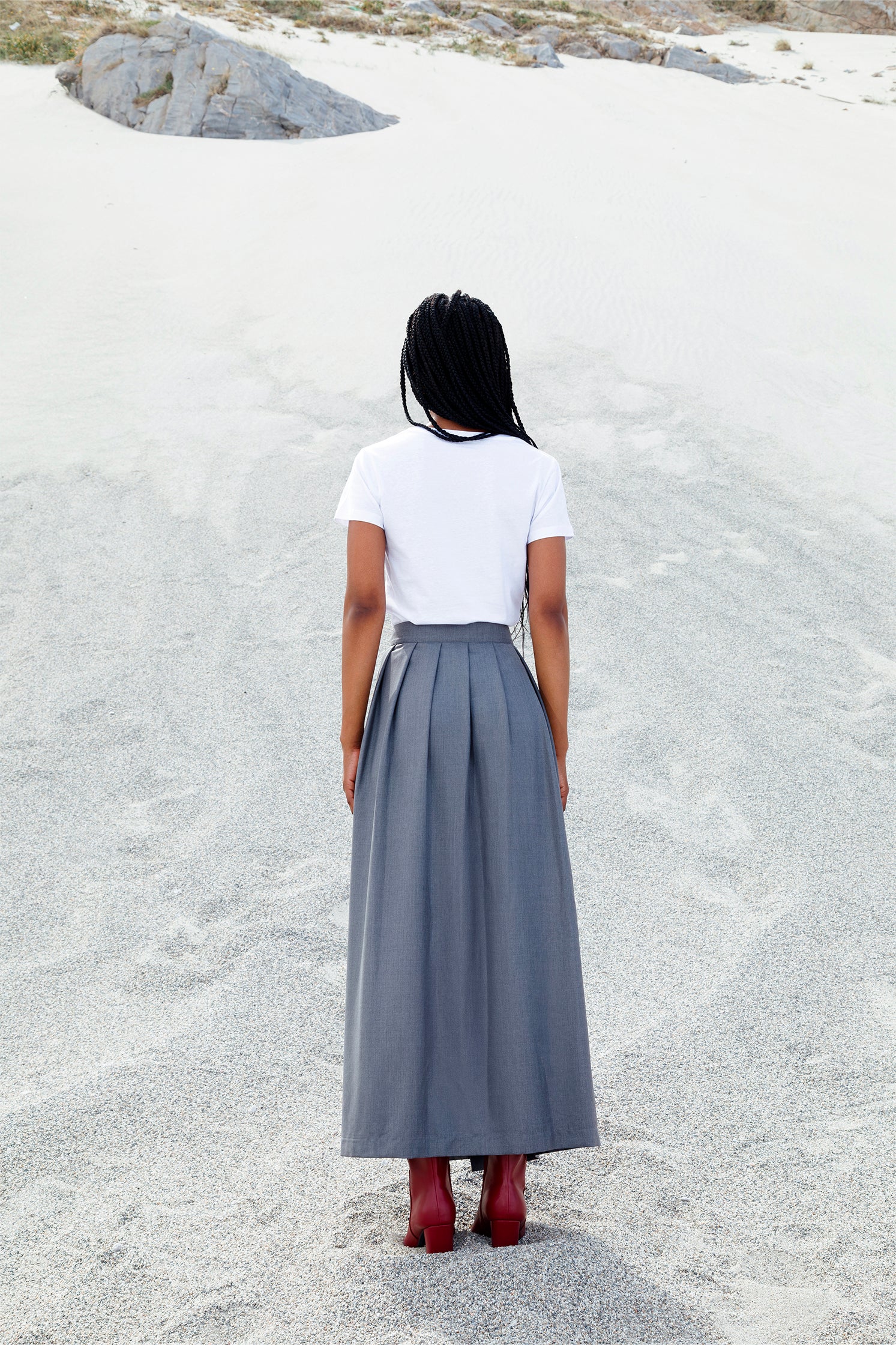 Close-up of the well-defined back folds of the long gray wrap skirt, showing volume, movement, and sophisticated drape.
