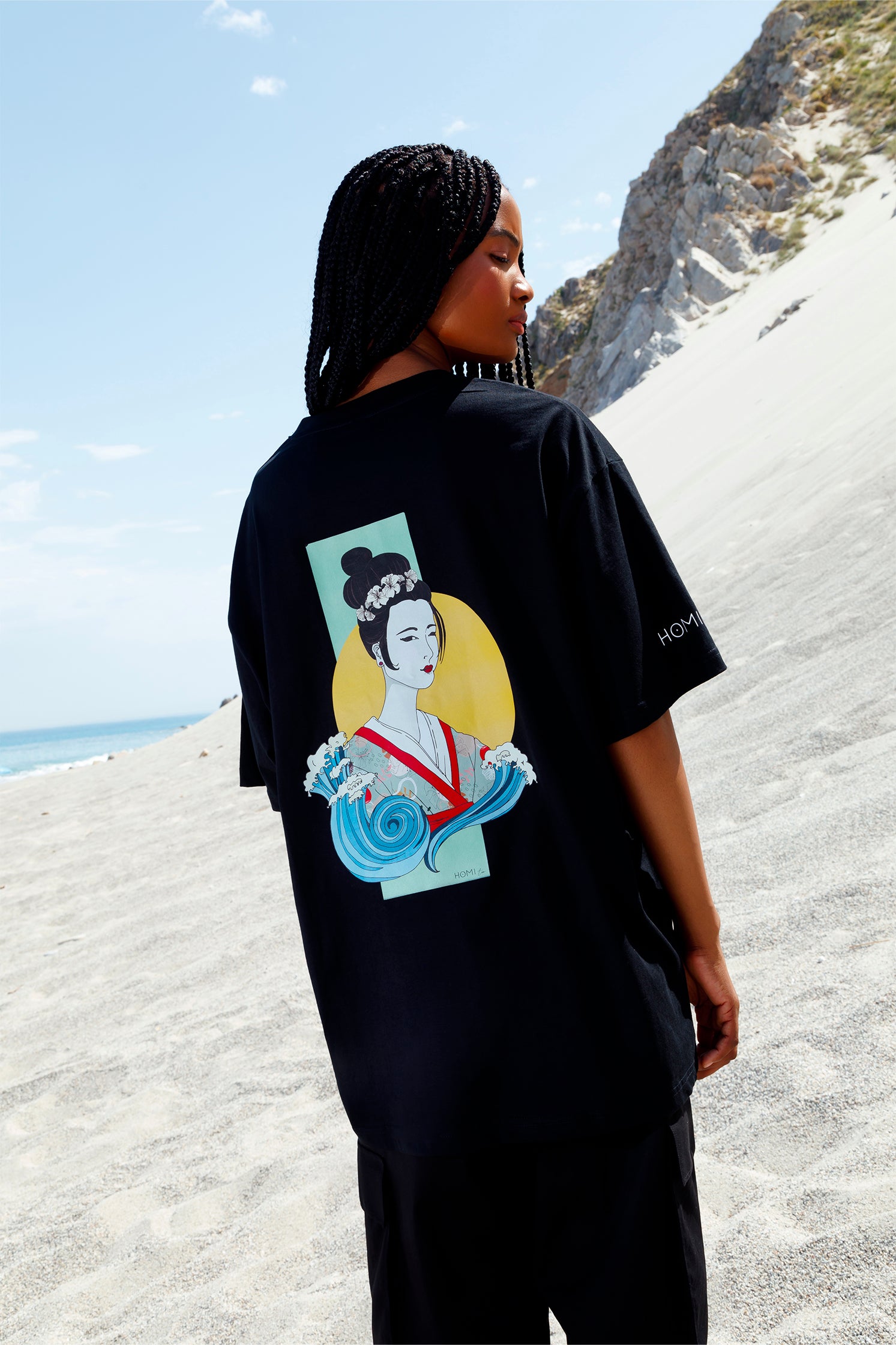 Back view of black short-sleeved oversized unisex t-shirt worn by a model, featuring hand-painted Geisha graphic printed with vibrant colors and artistic details.