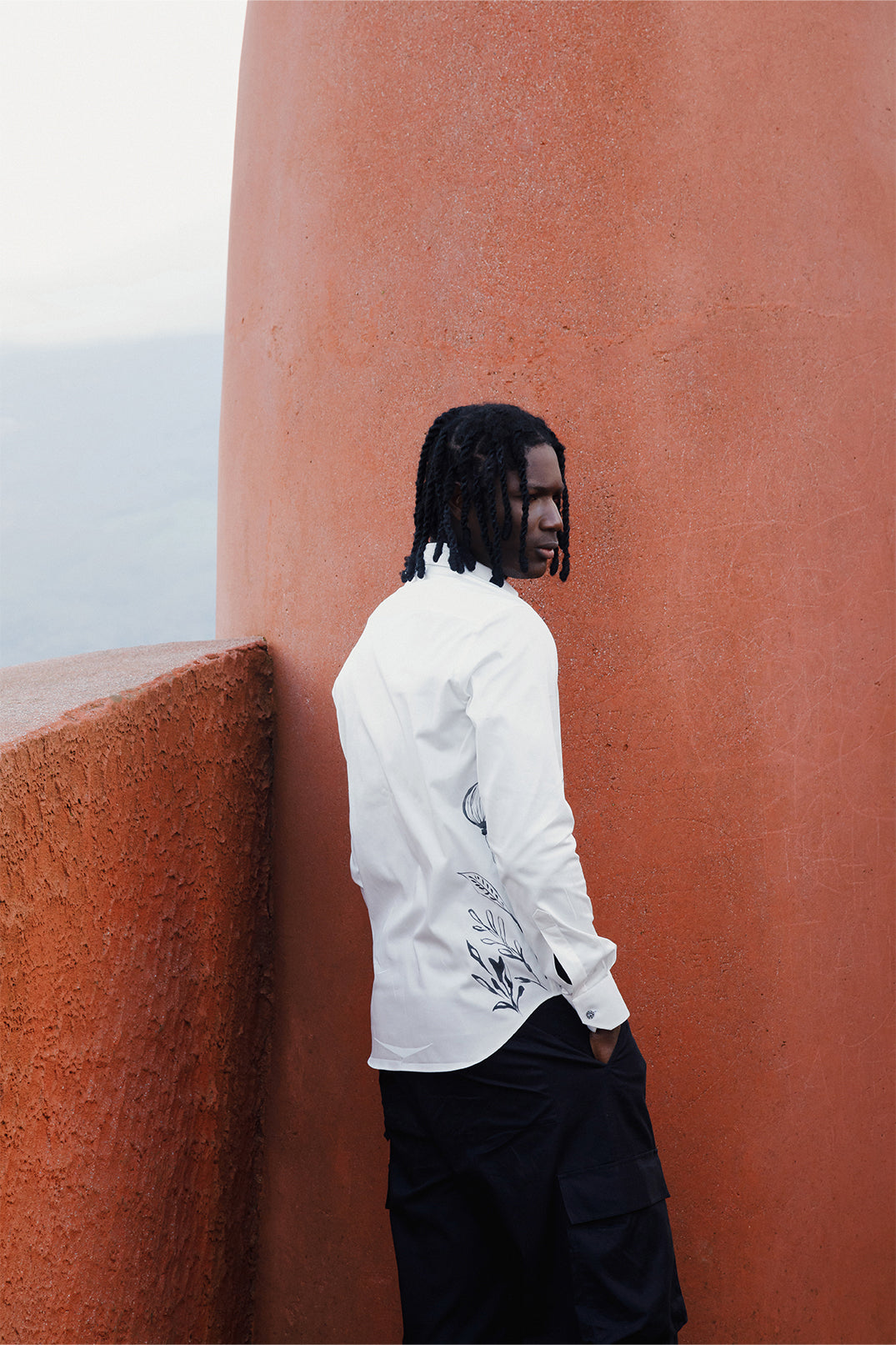 Back view of the white cotton shirt hand-painted with original brushstrokes applied directly on the fabric, worn by a model.
