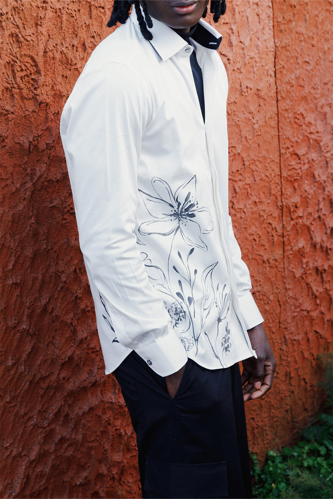 Side view of the white cotton shirt hand-painted with original brushstrokes applied directly on the fabric, worn by a model.