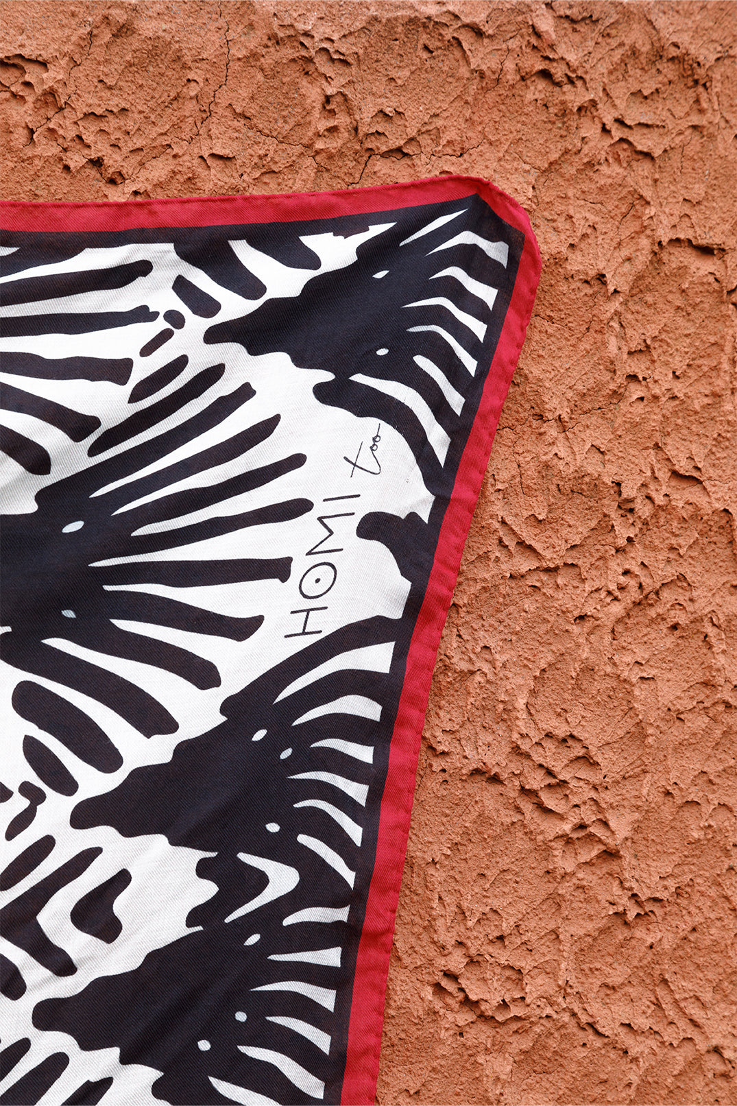 Close-up of the scarf with black and white fan motif, red border.
