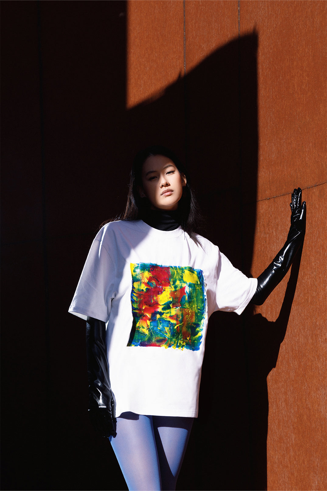 White unisex oversized T-shirt worn by a model, with central multicolor square hand-made using an exclusive silicone technique.