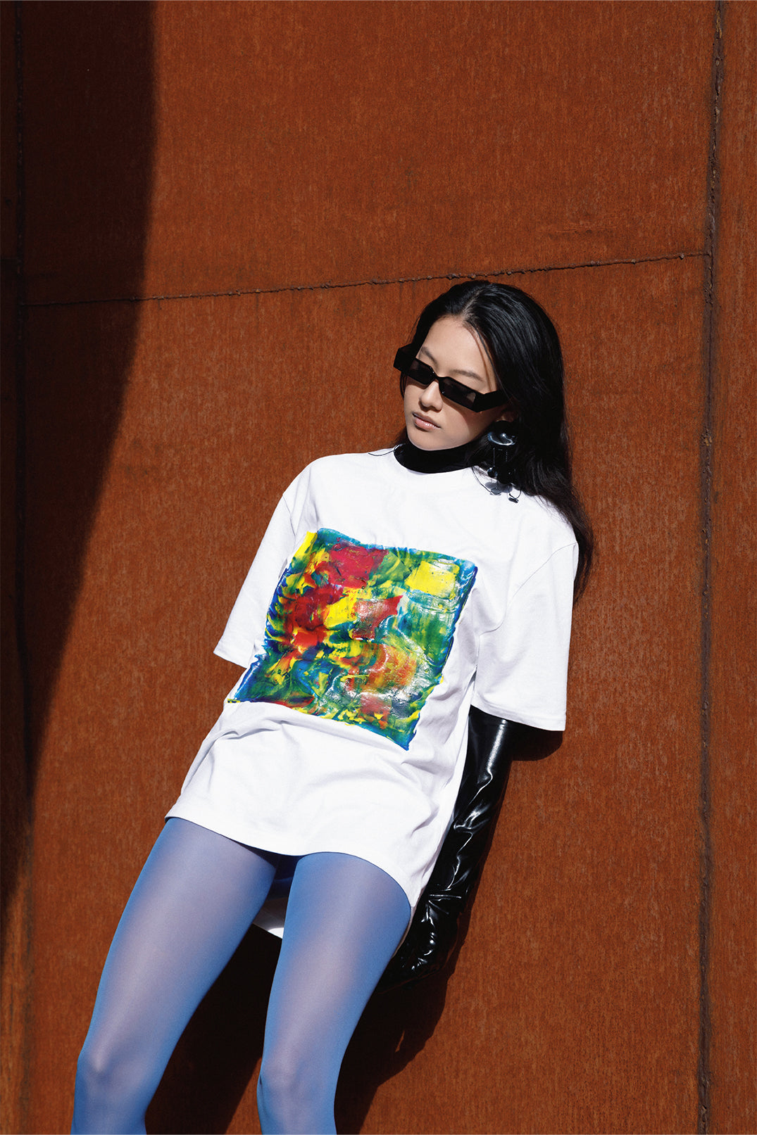 SIde view of the white unisex oversized T-shirt worn by a model, with central multicolor square hand-made using an exclusive silicone technique.