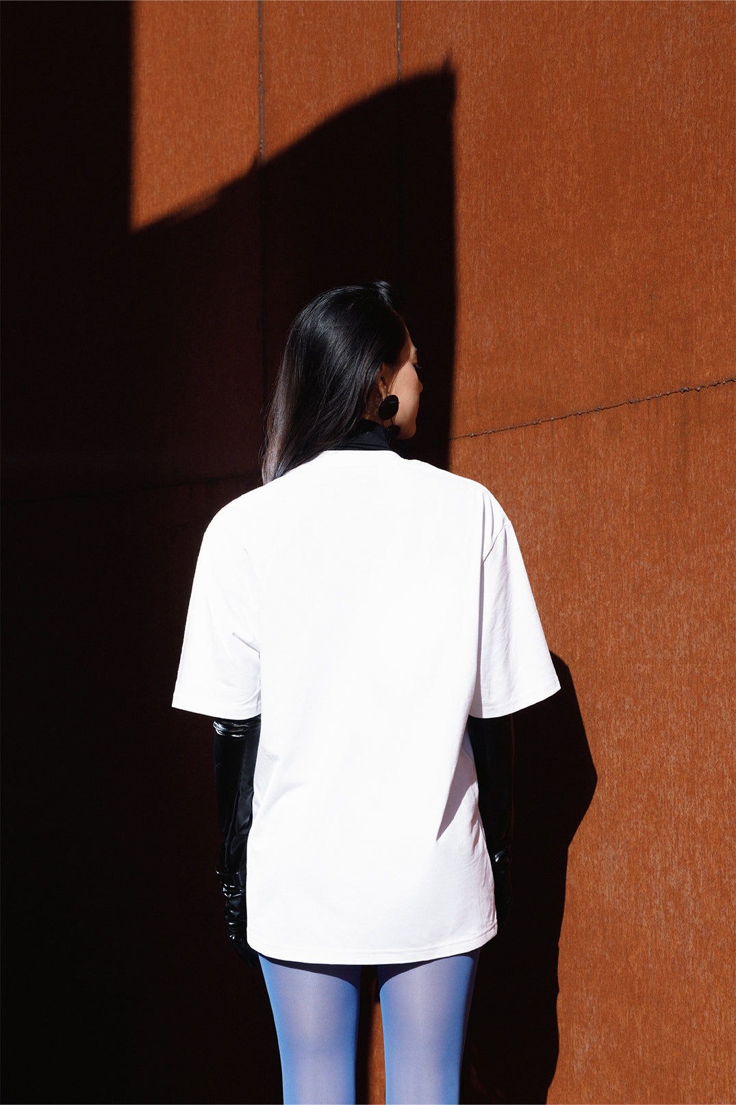 Back view of the white unisex oversized T-shirt worn by a model.