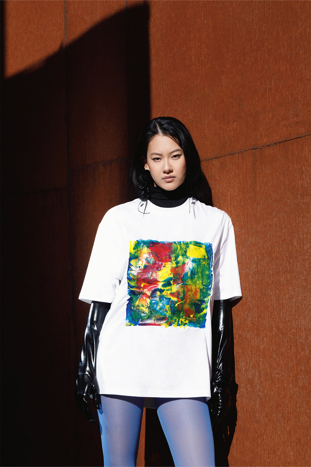 White unisex oversized T-shirt worn by a model, with central multicolor square hand-made using an exclusive silicone technique.