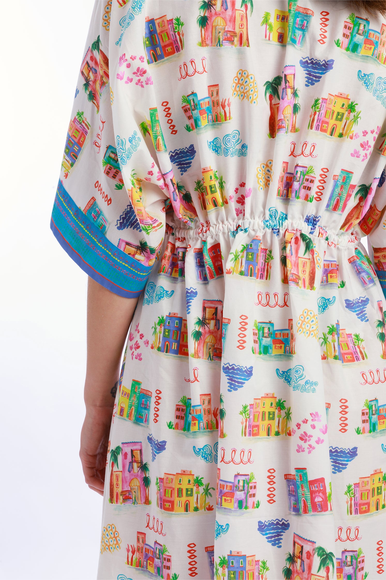 Close-up of the "Casette" print on the wrap dress, showing vibrant colors, painterly details and original Mediterranean-inspired motif.
