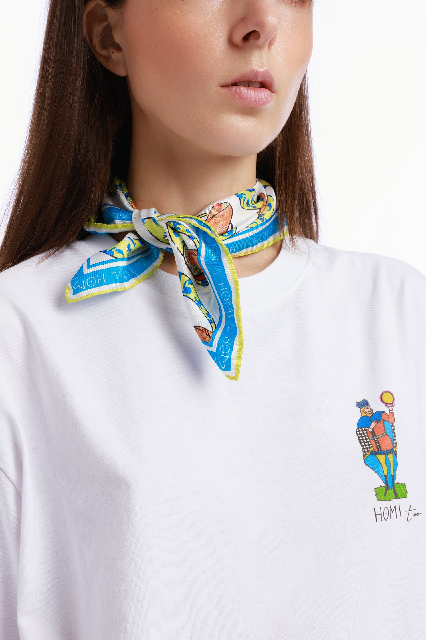 Pure silk 45x45 cm scarf inspired by Sicilian pastry tradition, depicting the famous cannolo, worn around the neck by a model with vibrant colors and decorative details.