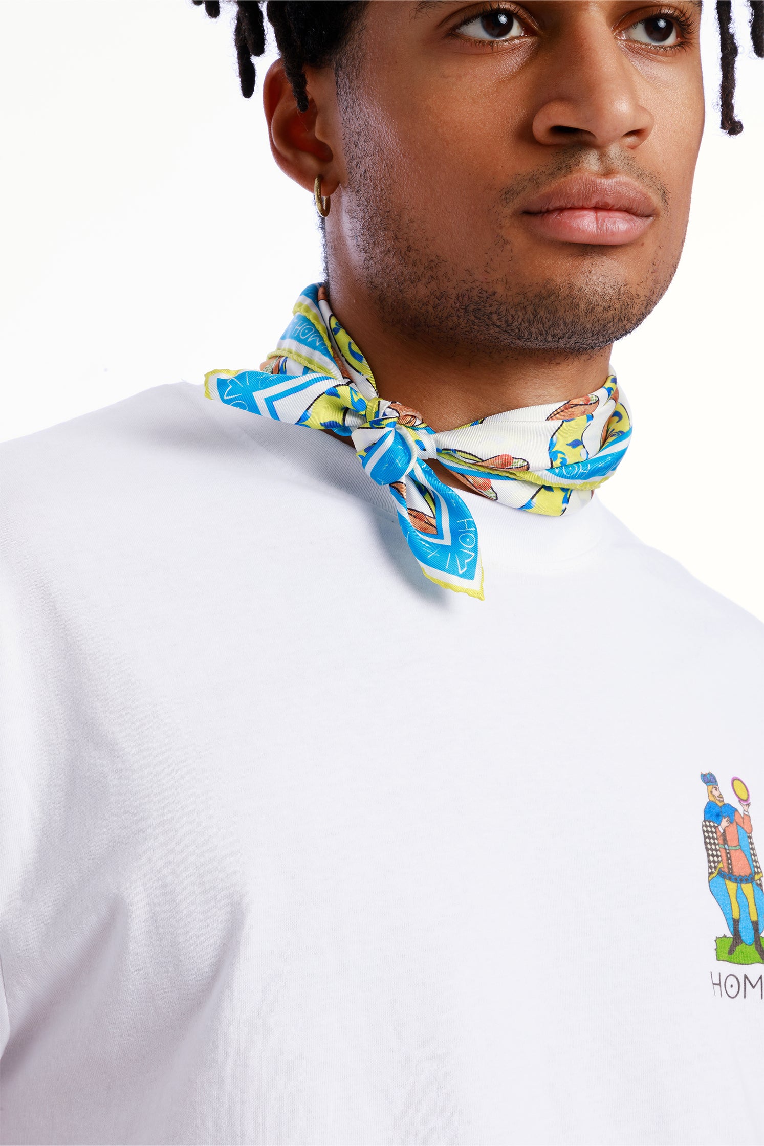 Pure silk 45x45 cm scarf inspired by Sicilian pastry tradition, depicting the famous cannolo, worn around the neck by a model with vibrant colors and decorative details.