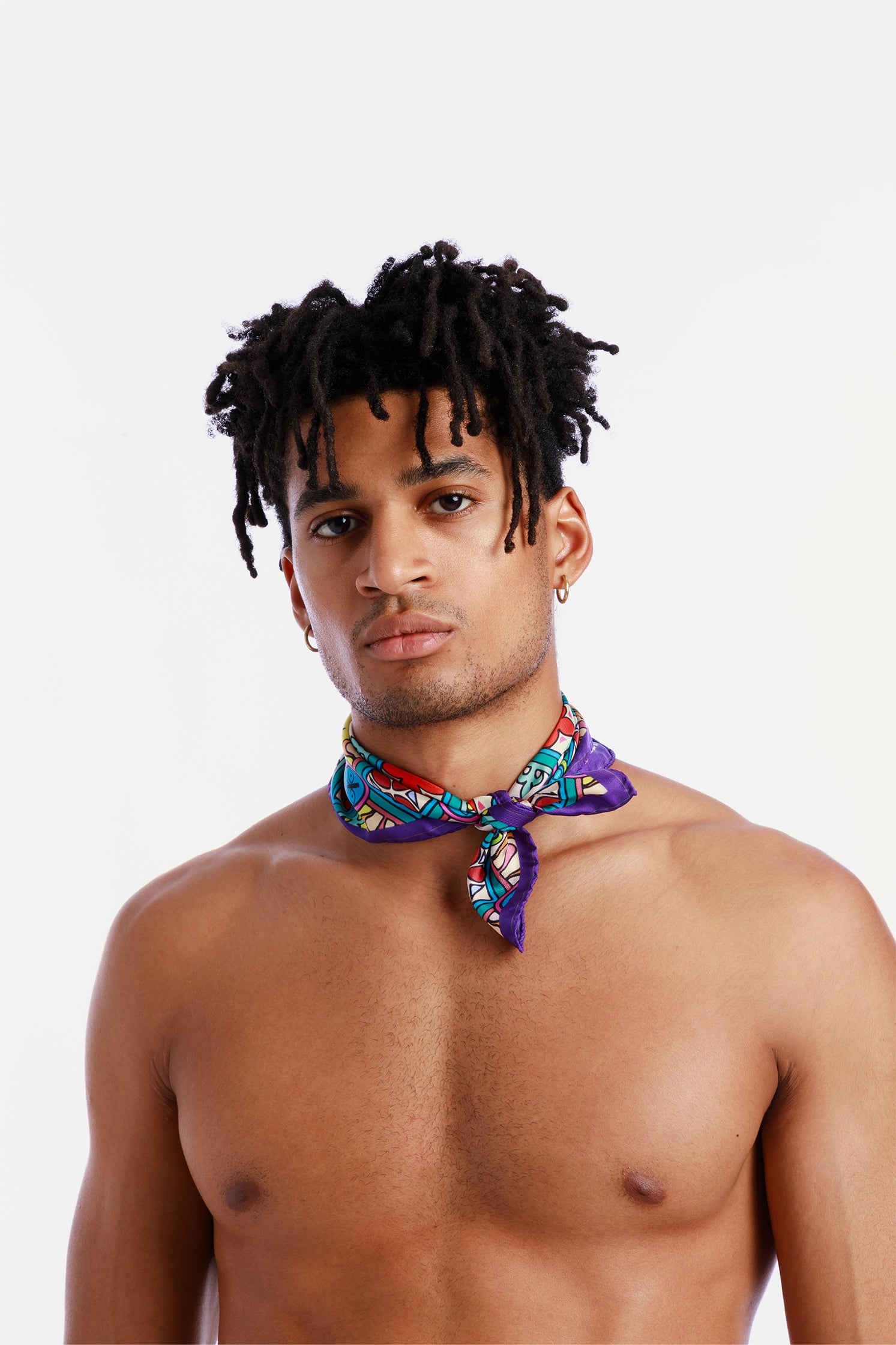 Pure silk 45x45 cm scarf inspired by Sicilian majolica, worn around the neck by a model, featuring vibrant geometric and floral motifs evoking the art and tradition of Sicily.