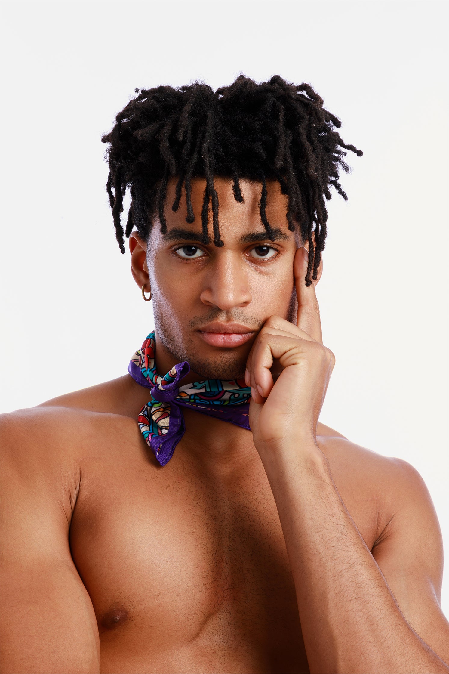 Pure silk 45x45 cm scarf inspired by Sicilian majolica, worn around the neck by a model, featuring vibrant geometric and floral motifs evoking the art and tradition of Sicily.