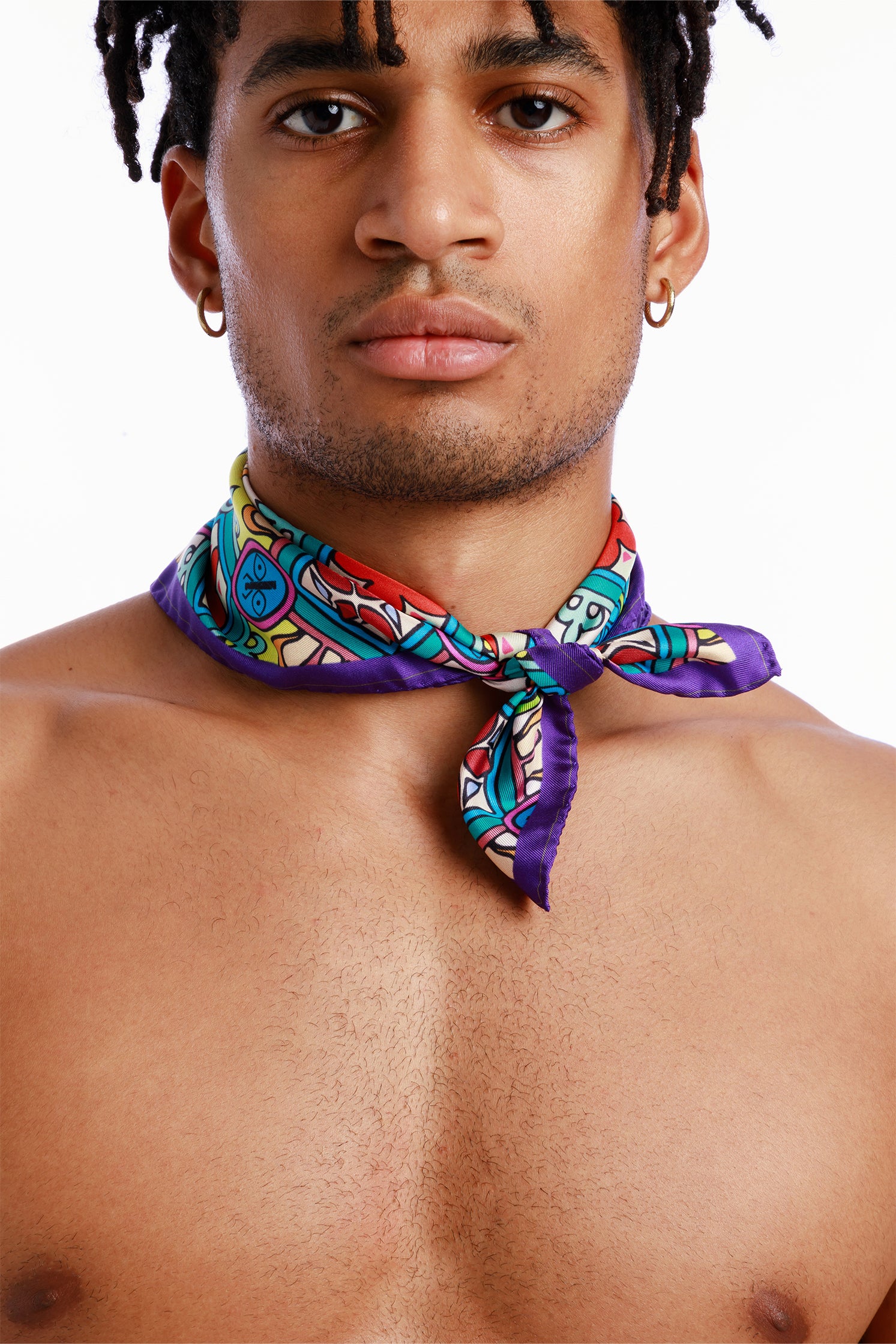 Pure silk 45x45 cm scarf inspired by Sicilian majolica, worn around the neck by a model, featuring vibrant geometric and floral motifs evoking the art and tradition of Sicily.