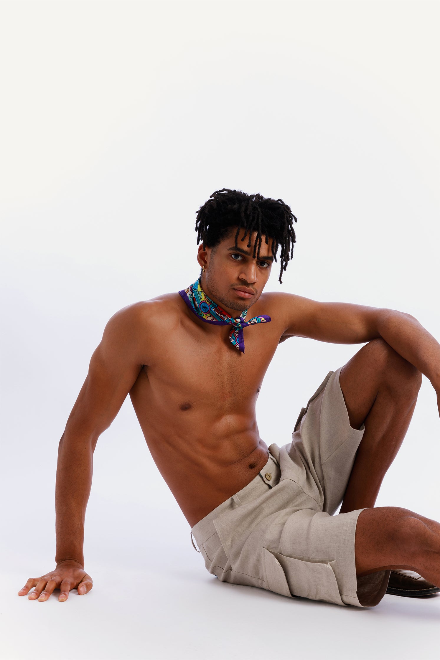 Pure silk 45x45 cm scarf inspired by Sicilian majolica, worn around the neck by a model, featuring vibrant geometric and floral motifs evoking the art and tradition of Sicily.